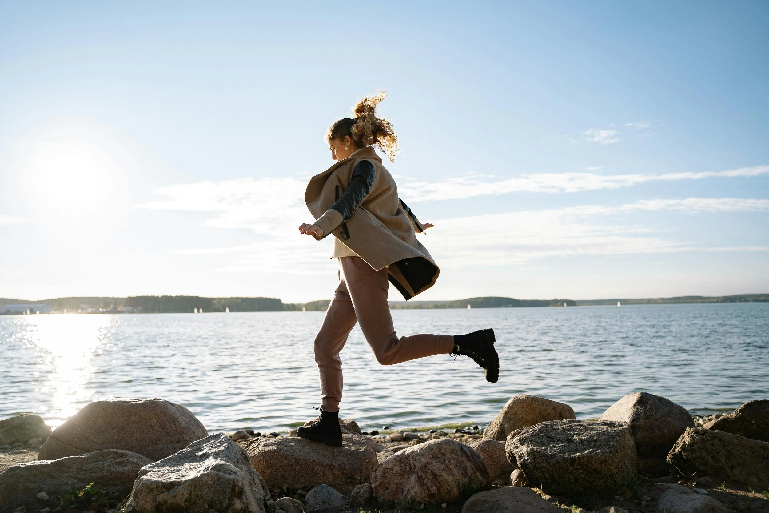 A woman jumping over rocks