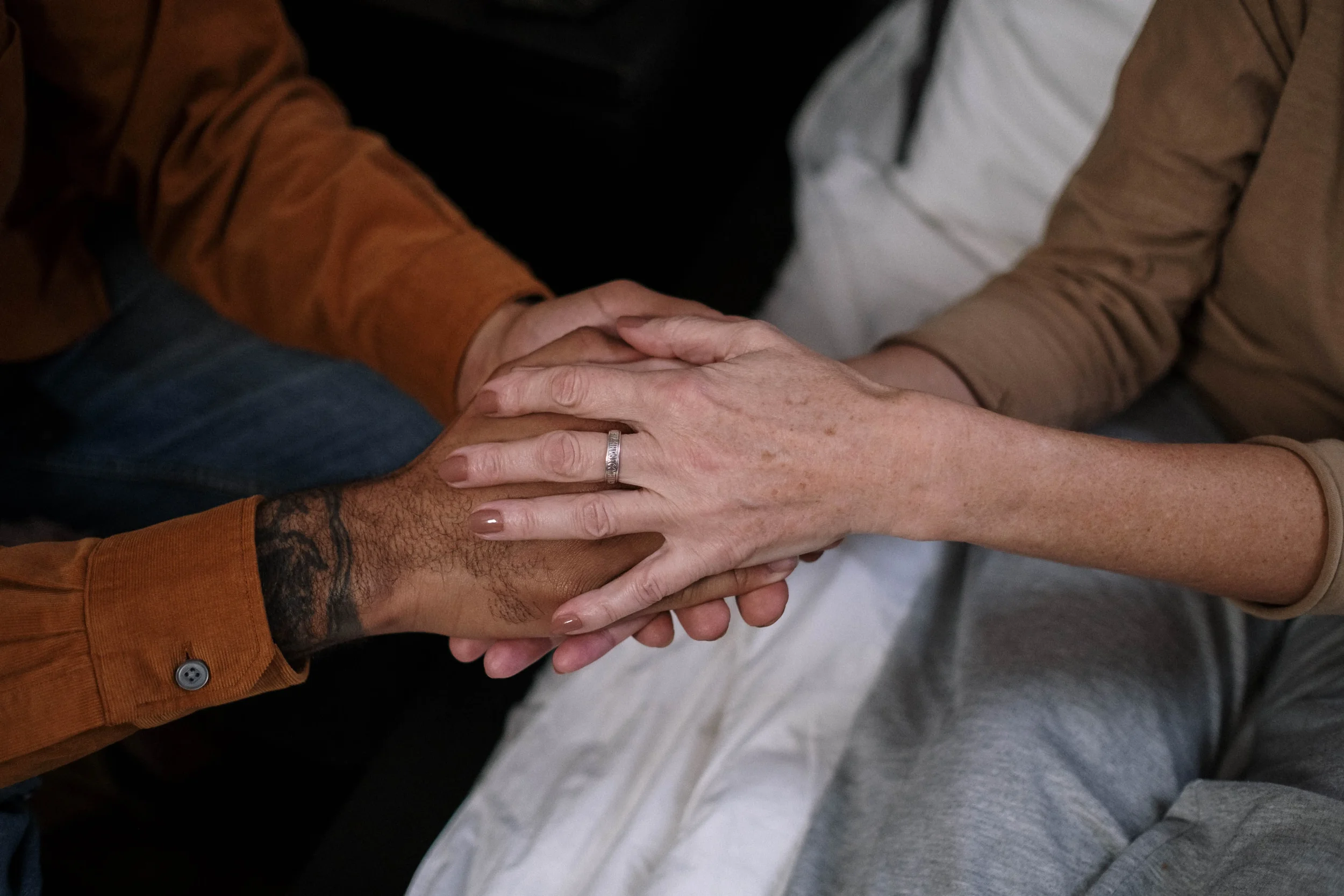 Two people holding hands in a comforting manner
