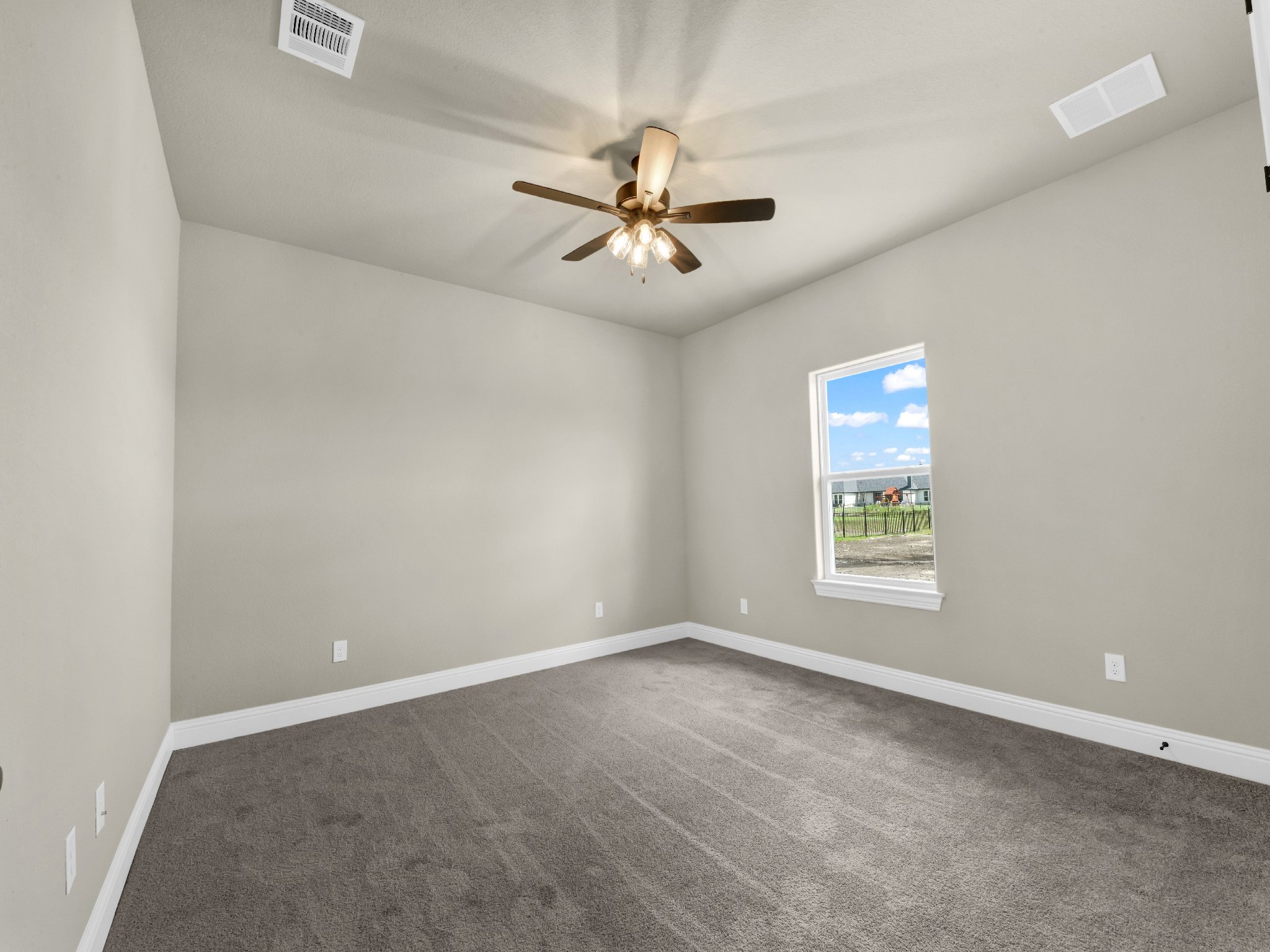 Empty room with carpet, ceiling fan, window, and white walls.