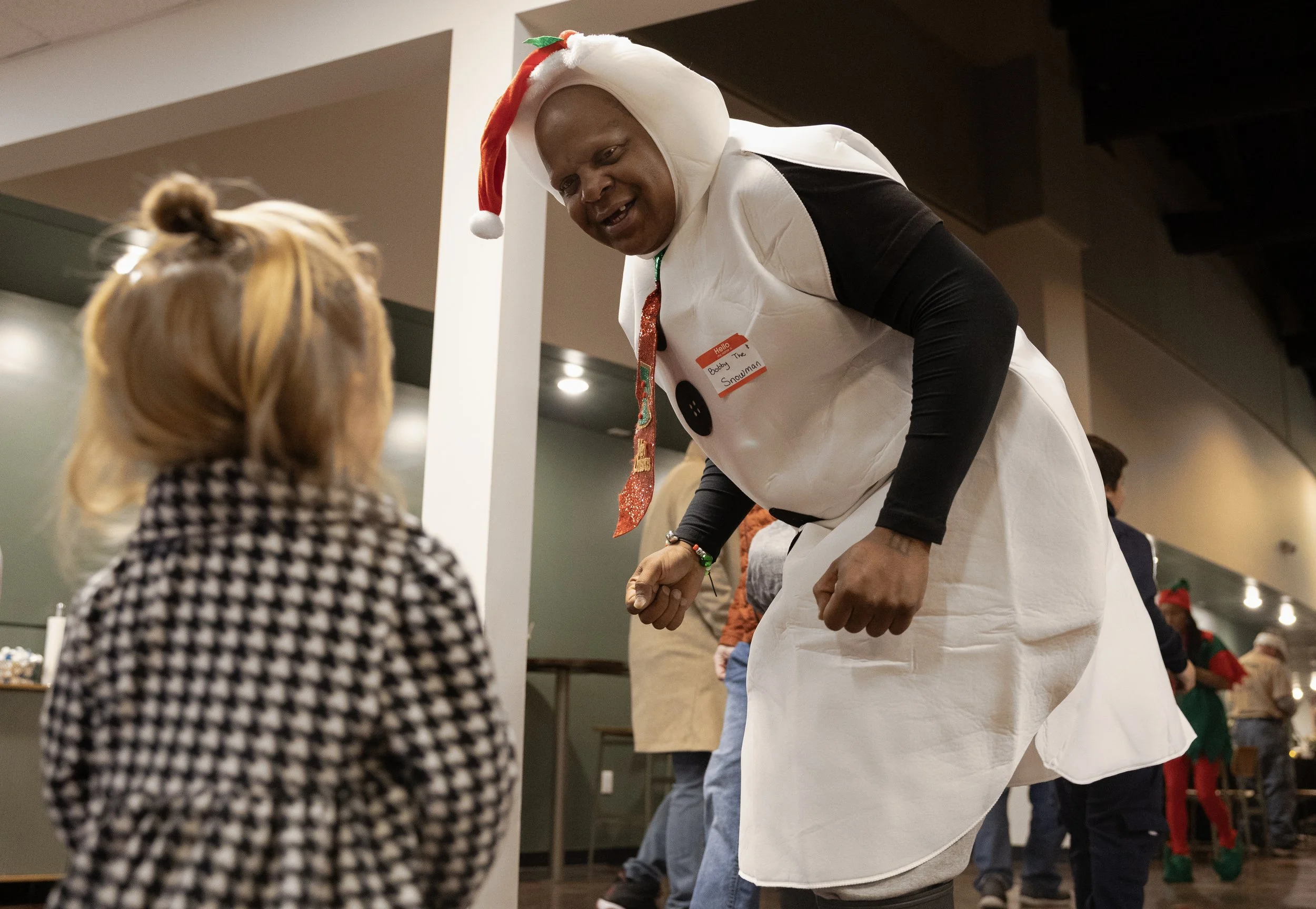 Bobby the Snowman entertains Serenity Young, 2, during the annual in2Action Christmas party. Bobby has nine kids of his own, ranging from ages 11 to 21. He makes sure to call them regularly each week. 