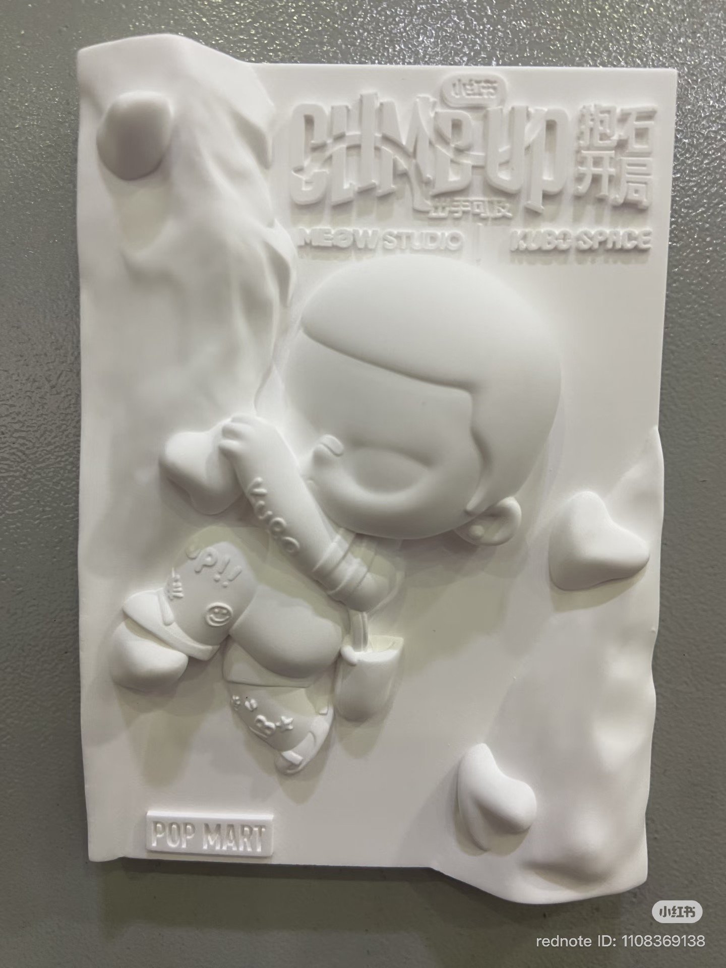 A “CLIMB UP” KUBO relief magnet—an all-white keepsake from the climbing activation.