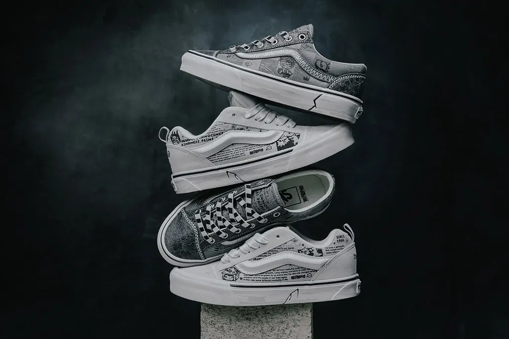 Pair of grey Vans Old Skools covered in Pop Mart Hirono doodles, stacked heel‑to‑toe against dark backdrop.