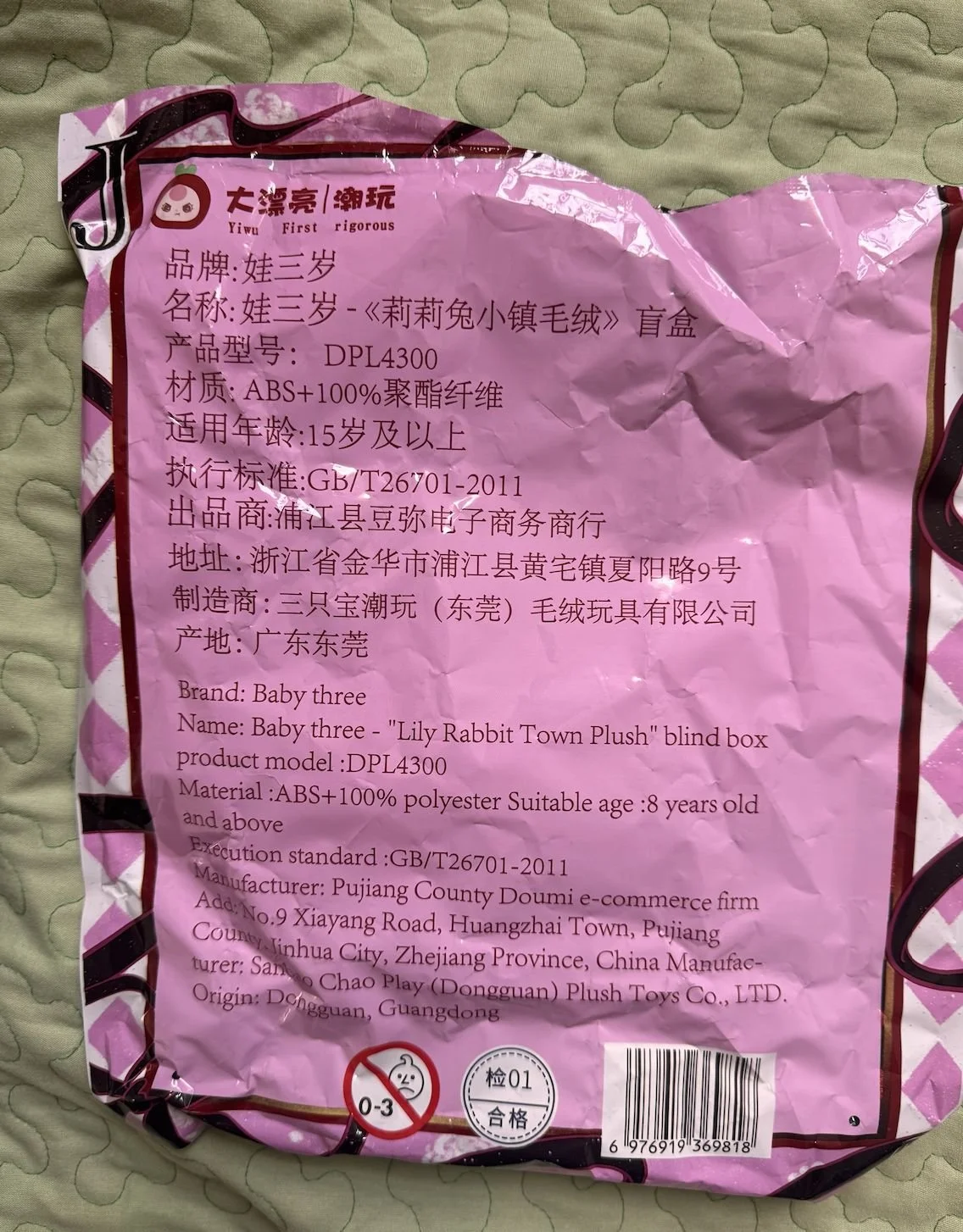 Back of a pink foil pouch covered in bilingual Chinese‑English text: brand “Baby three”, name “Lily Rabbit Town Plush”, model DPL4300, materials, age rating, manufacturer address and barcode.