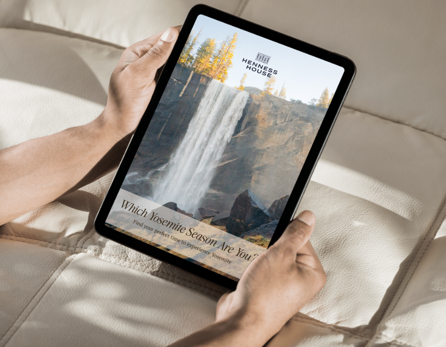 Person holding a tablet displaying a promotional page for Yosemite, showing a waterfall, with text about finding the perfect Yosemite season.