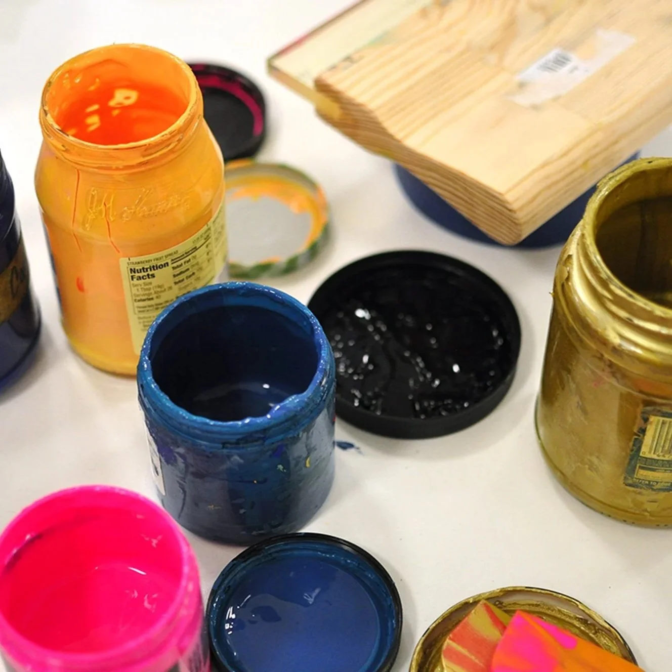 Jars of ink and a squeegee on a table.