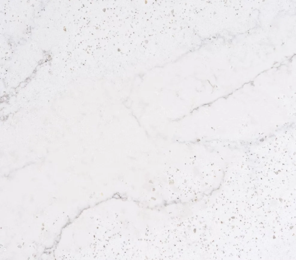 Close-up of a white marble surface with subtle gray veining and specks.