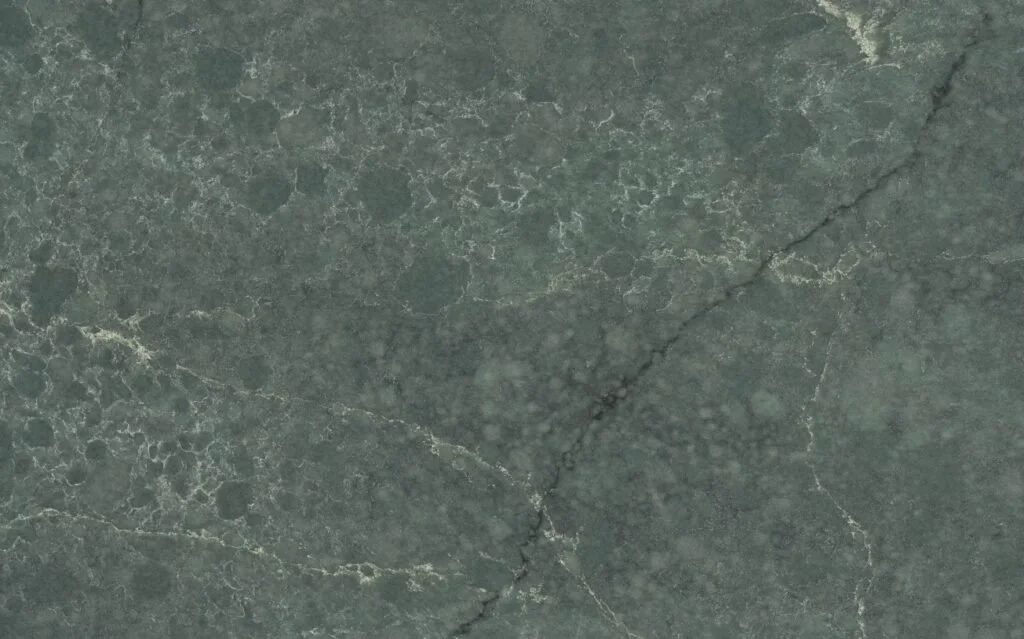 Close-up of a gray-green marble surface with natural veining and crack lines.
