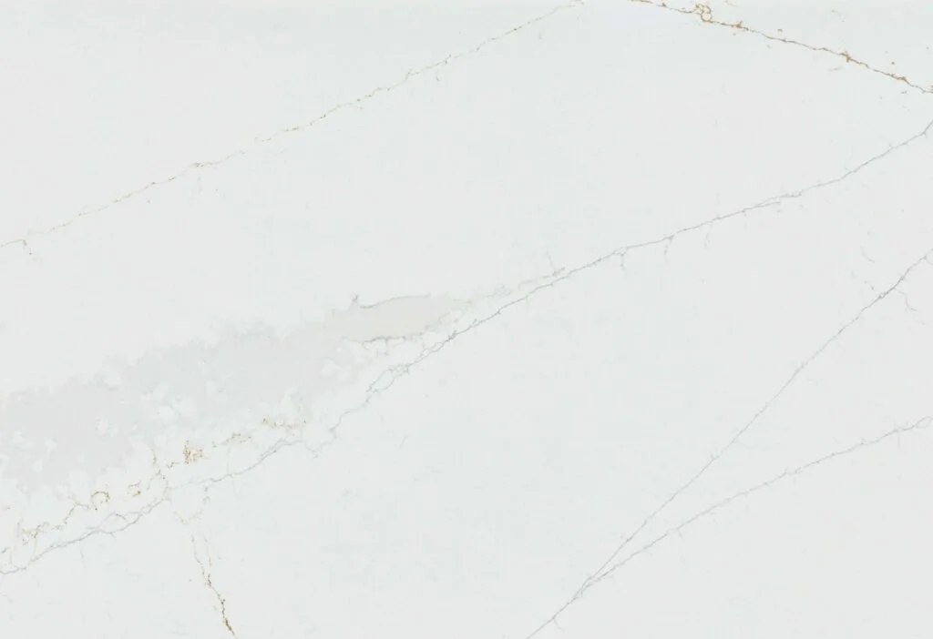 Close-up of a white marble surface with faint gray and light brown veining.
