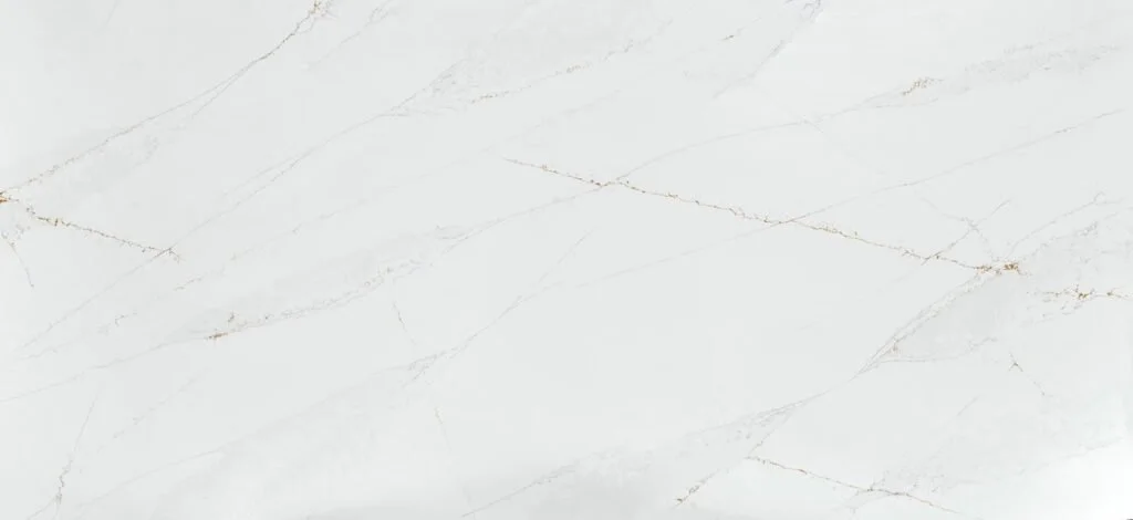 A white marble surface with subtle gold and gray veining.