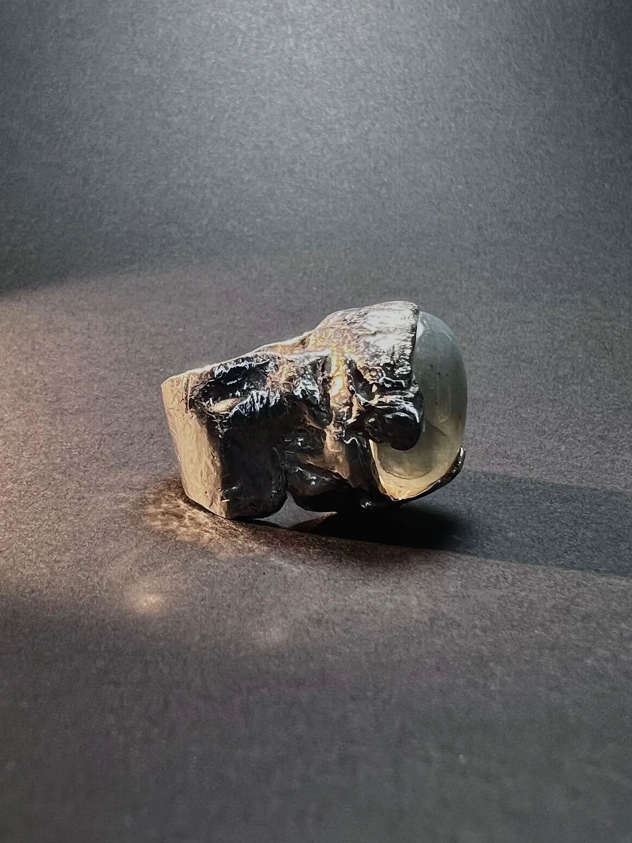 A scallop shell with blackened and charred areas on a dark surface.