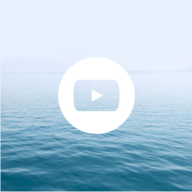 A play button overlay on a calm ocean scene with a clear sky in the background.