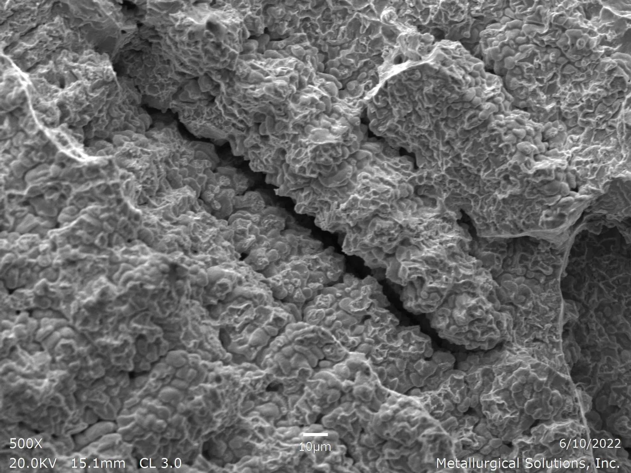 Interdendritic fracture 500x, scanning electron microscope SEM fractography evaluation analyzing a brittle interdendritic separation mode along a cast alloy solidification network per ASTM E3 under ISO 17025 accredited laboratory standards.
