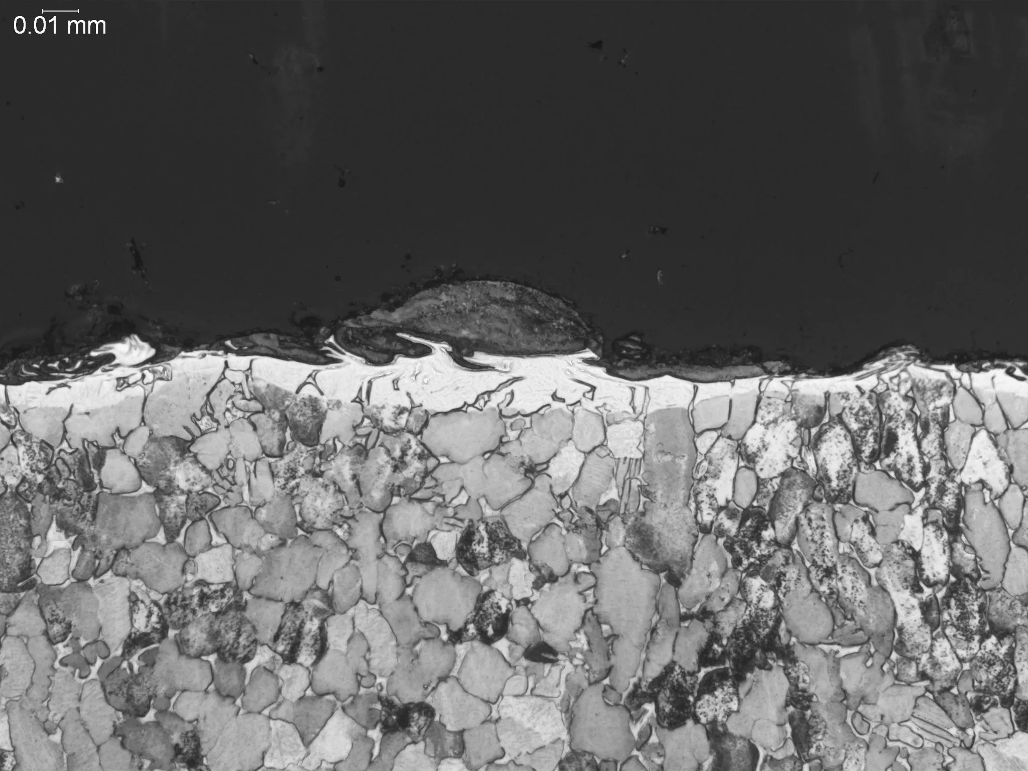 Electrical discharge machining (EDM) recast layer on a titanium matrix, metallographic cross-sectional evaluation identifying an EDM recast layer, discontinuous white layer profile, and subsurface microstructural grain modifications in a titanium all