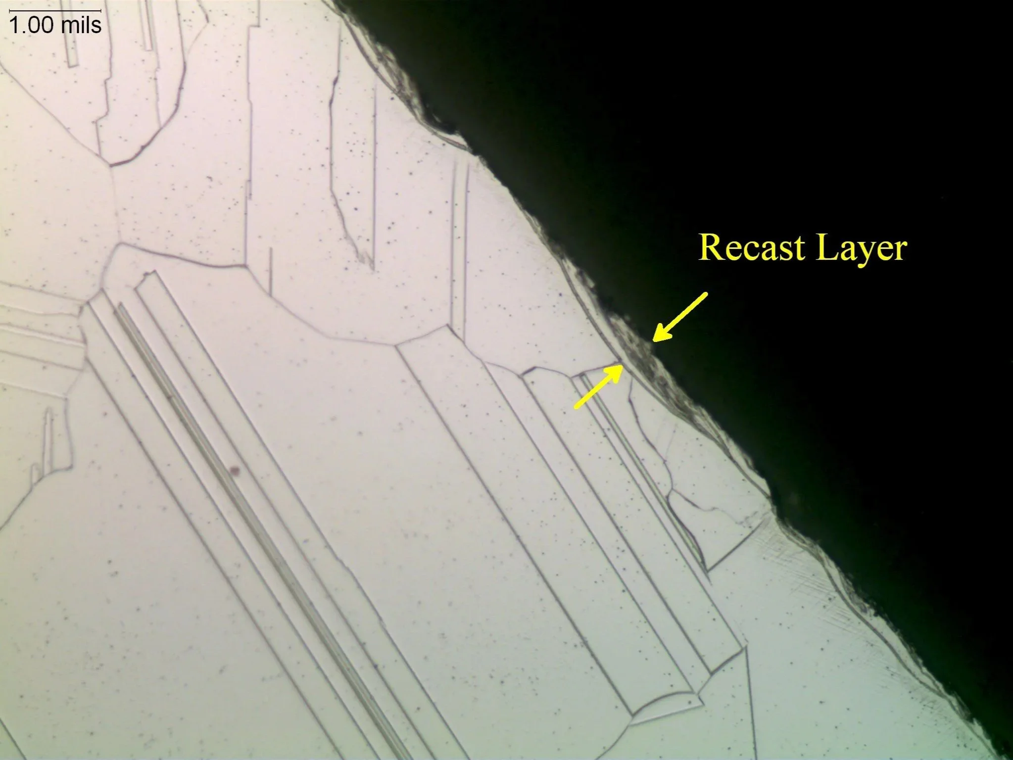 Electrical discharge machining (EDM) recast layer on a superalloy matrix, metallographic cross-sectional evaluation identifying an electrical discharge machining recast layer white layer profile, localized thermal alteration zone thickness, and an et