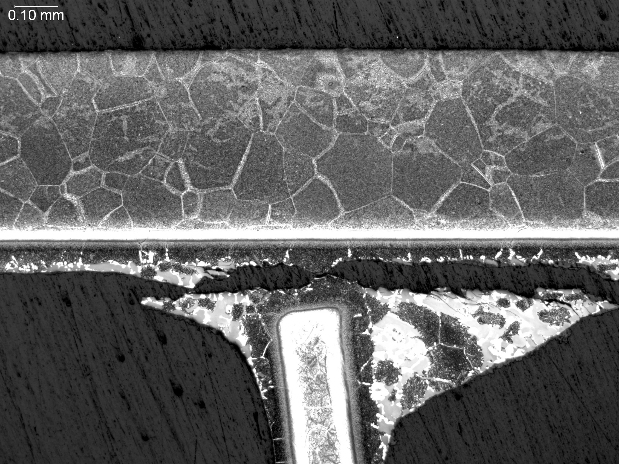Bad braze joint, metallographic cross-sectional evaluation revealing incomplete base metal wetting, extensive unbonded void clusters, and a fractured braze fillet interface profile per AWS C3.8M and ASTM E3 under ISO 17025 accredited laboratory stand