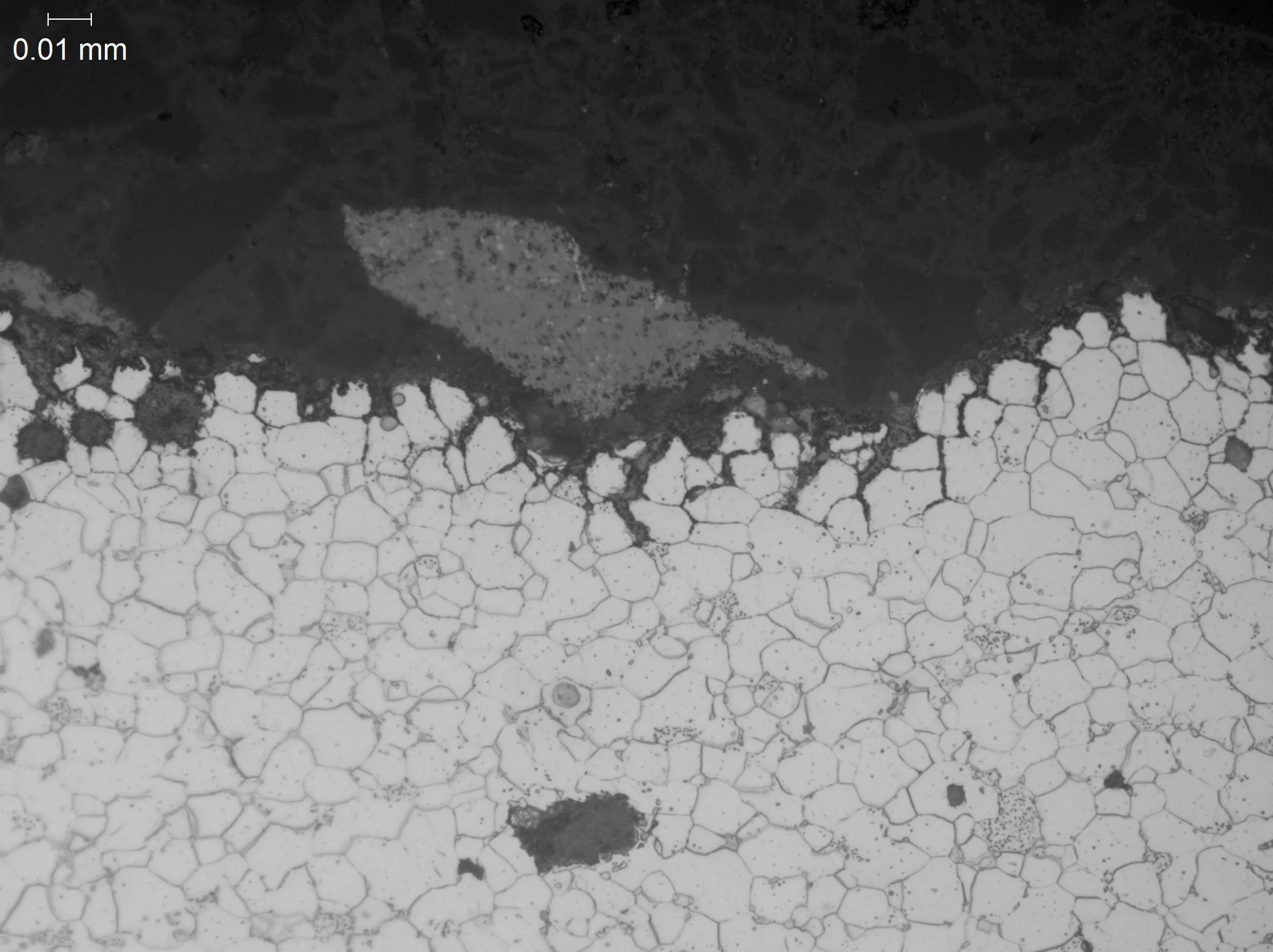 Intergranular oxidation (IGO) within a carbon steel boiler tube matrix, metallographic cross-sectional evaluation identifying localized grain boundary oxidation networks, surface scaling depletion zones, and isolated graphite nodules within an etched