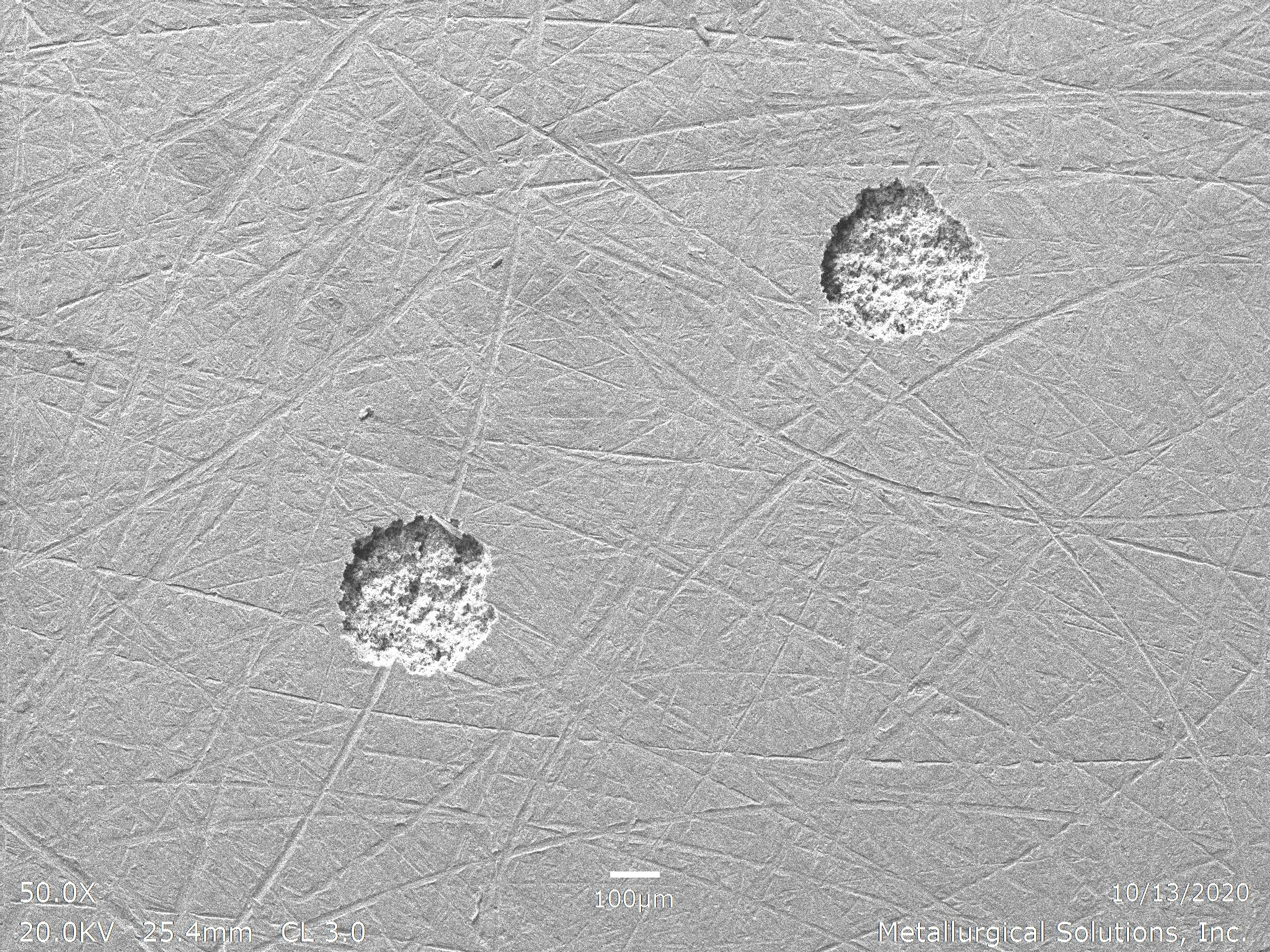 Isolated pitting corrosion SEI 50x, scanning electron microscope secondary electron imaging evaluation identifying localized pitting sites, surface pit initiation geometry, and porous oxidation remnants per ASTM G46 under ISO 17025 accredited laborat