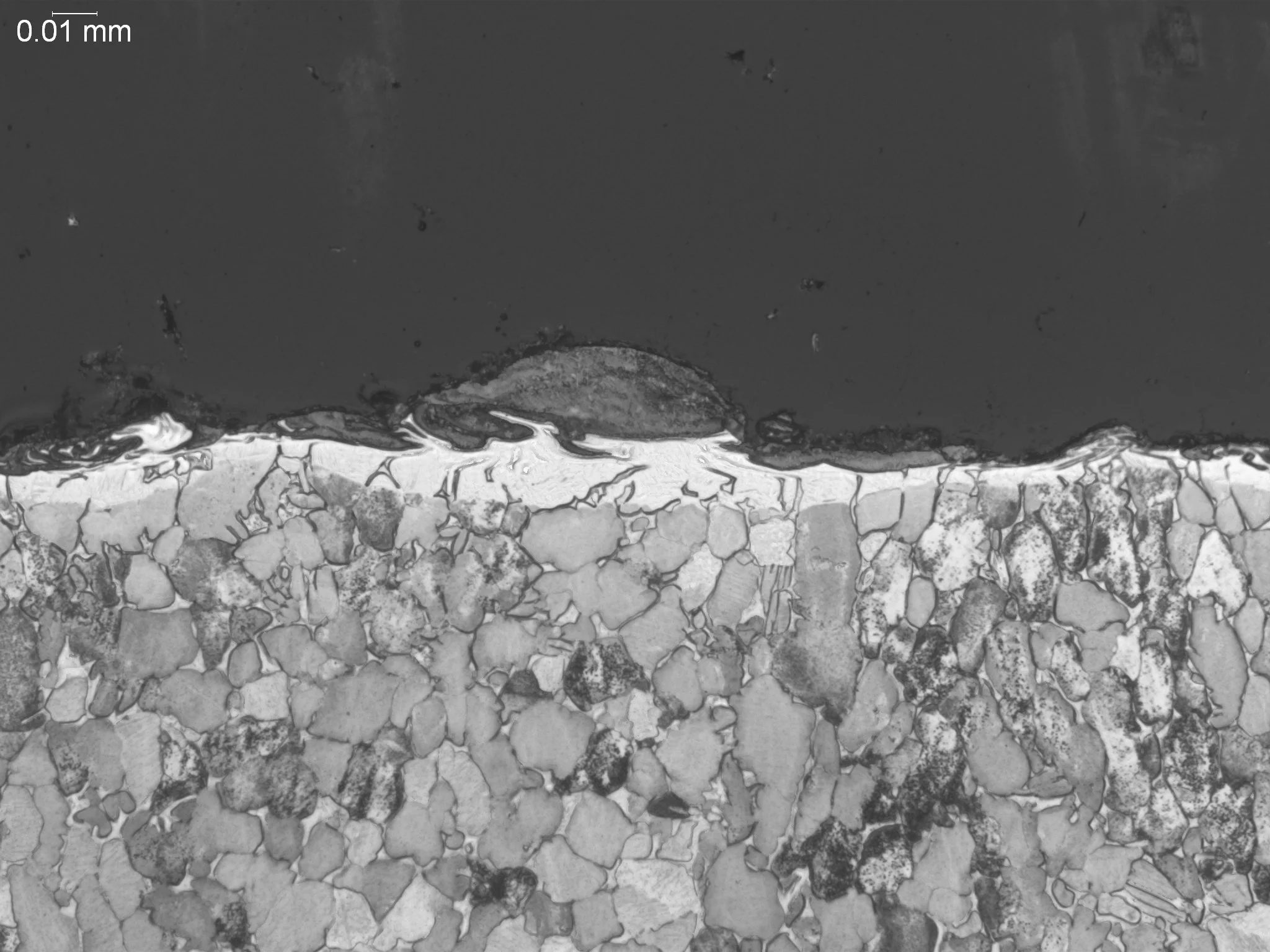 Electrical discharge machining (EDM) recast layer on a titanium matrix, metallographic cross-sectional evaluation identifying an EDM recast layer, discontinuous white layer profile, and subsurface microstructural grain modifications in a titanium all