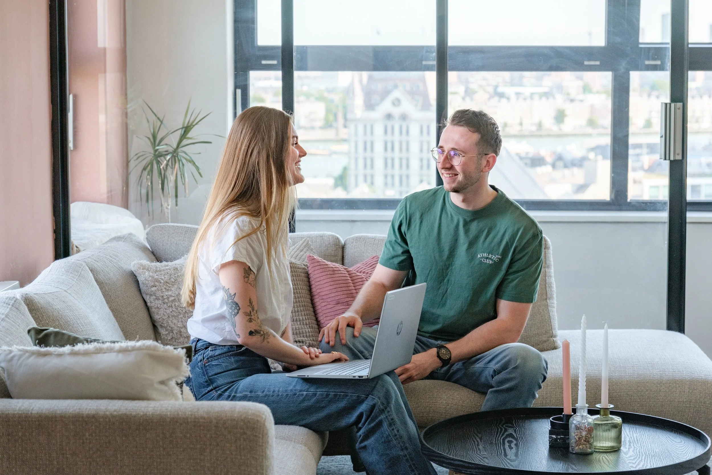 Beide trainers zitten op de bank en bespreken hoe ze een klant het best kunnen helpen.