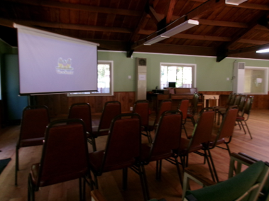 Room filled with empty chairs facing a projector.