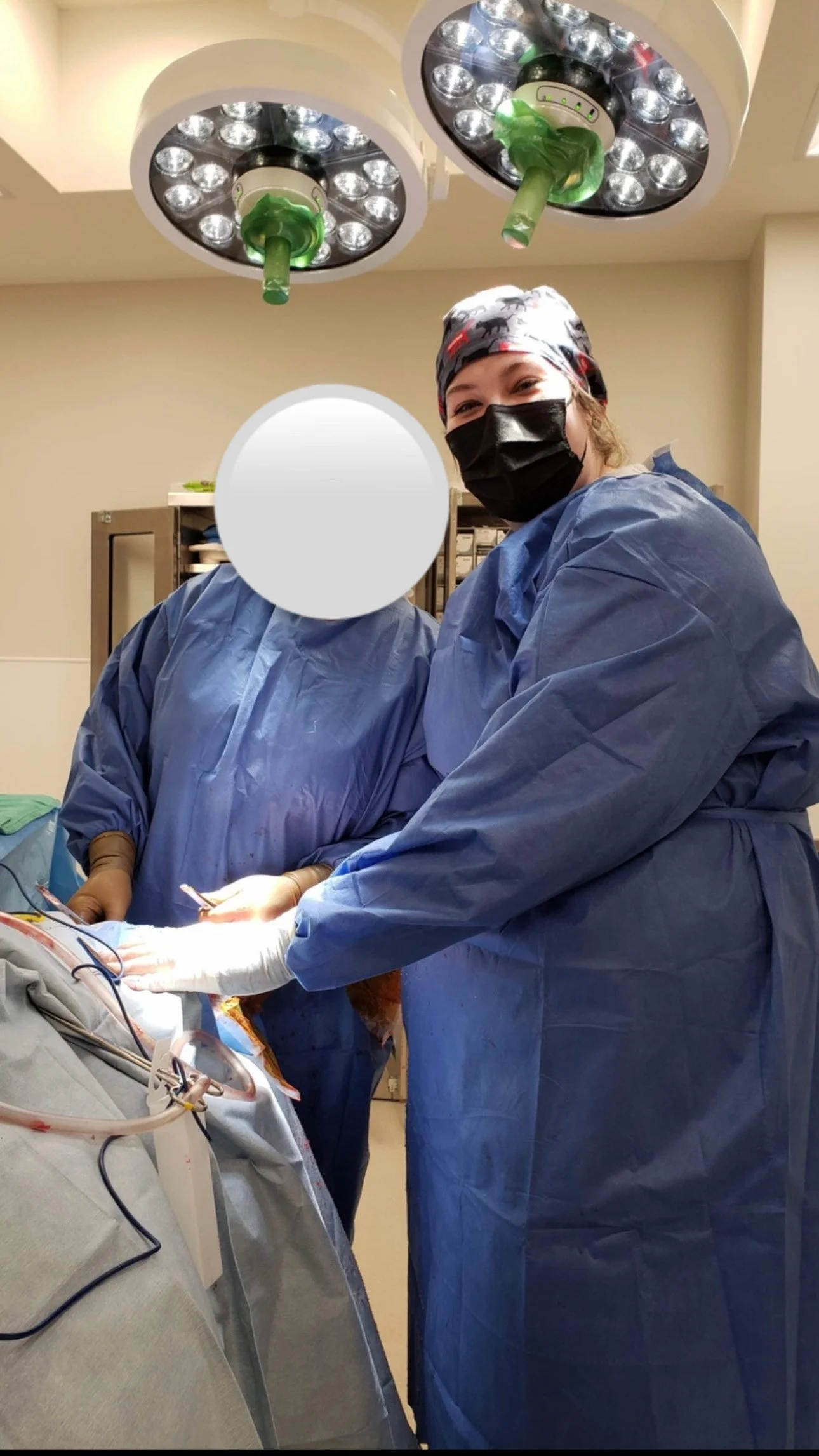 Veterinary surgical team performing a procedure in an operating room while wearing protective surgical equipment.