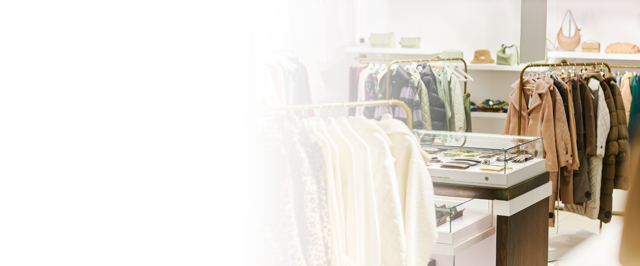 Interior of a boutique clothing store displaying coats and accessories.