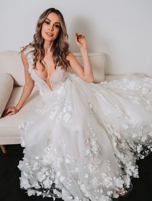 Woman in floral bridal gown sitting on a couch