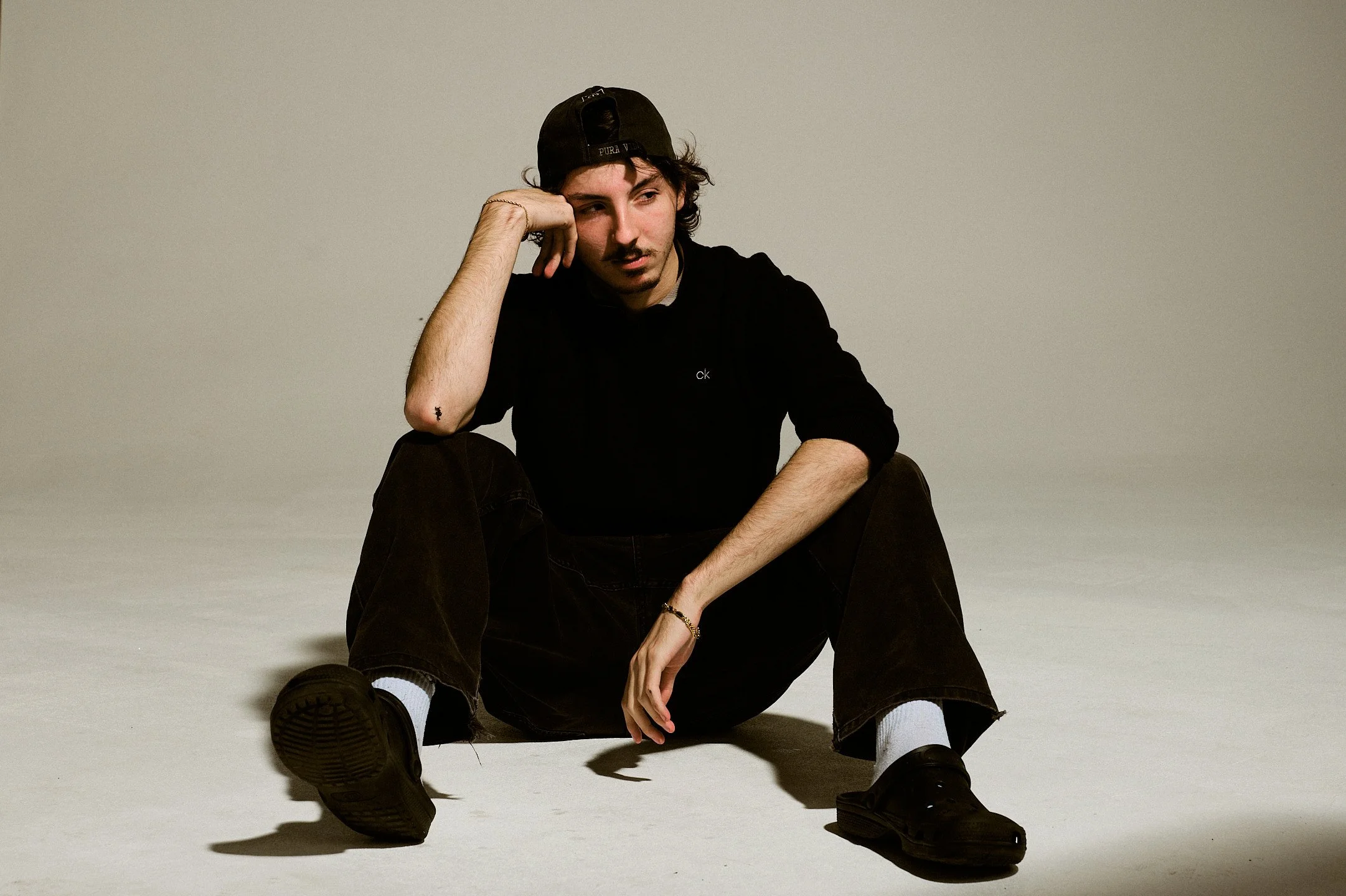 Zachary Bouchard, assieds par terre, acôté sur son bras.