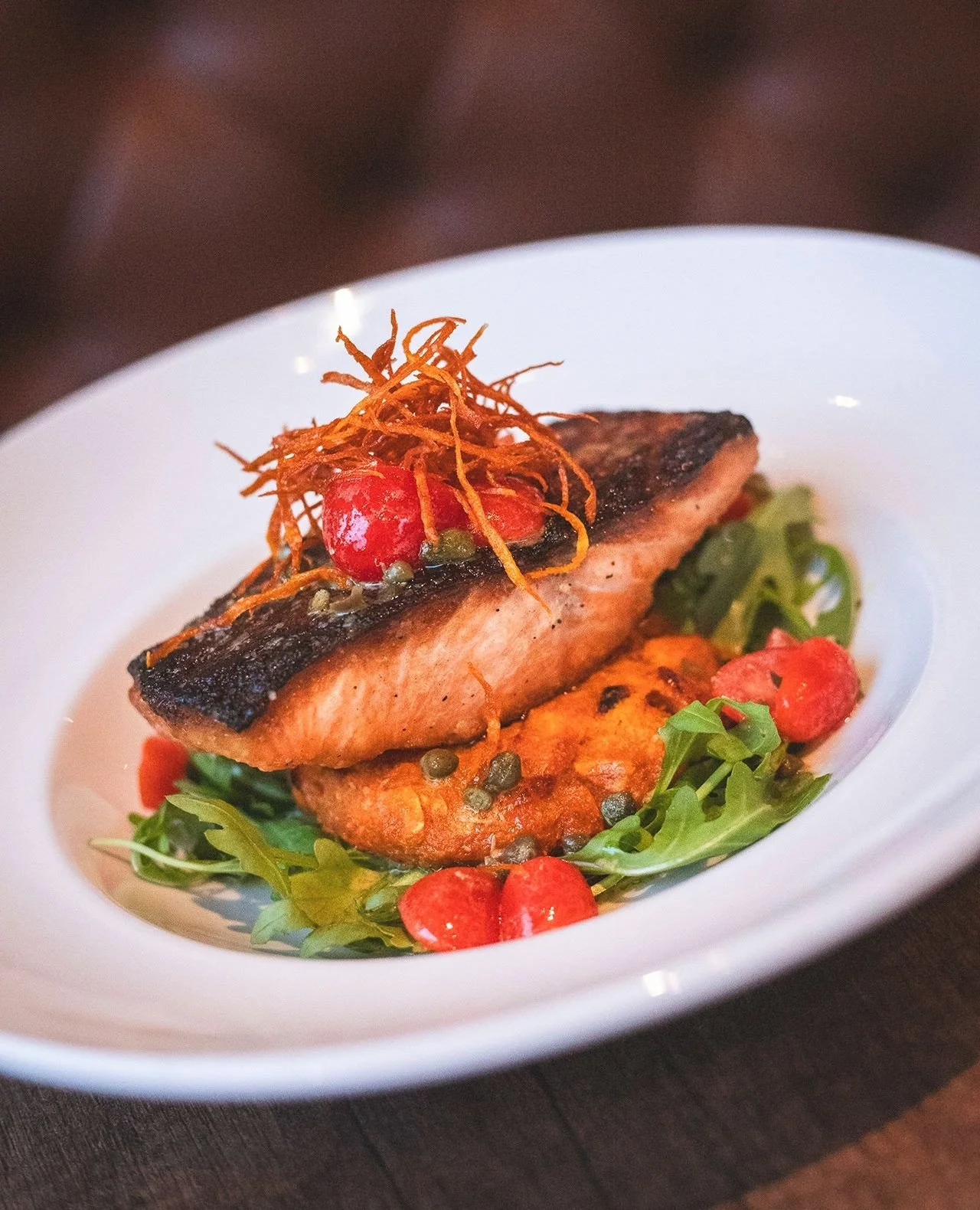 Tonight's plan, tell a friend 🦪 Dollar Oysters (4&ndash;5:30pm) and this Wood Oven Roasted Salmon over sweet potato cake, arugula, Dijon-caper-grape tomato vinaigrette, and sweet potato hay. See you in a few!