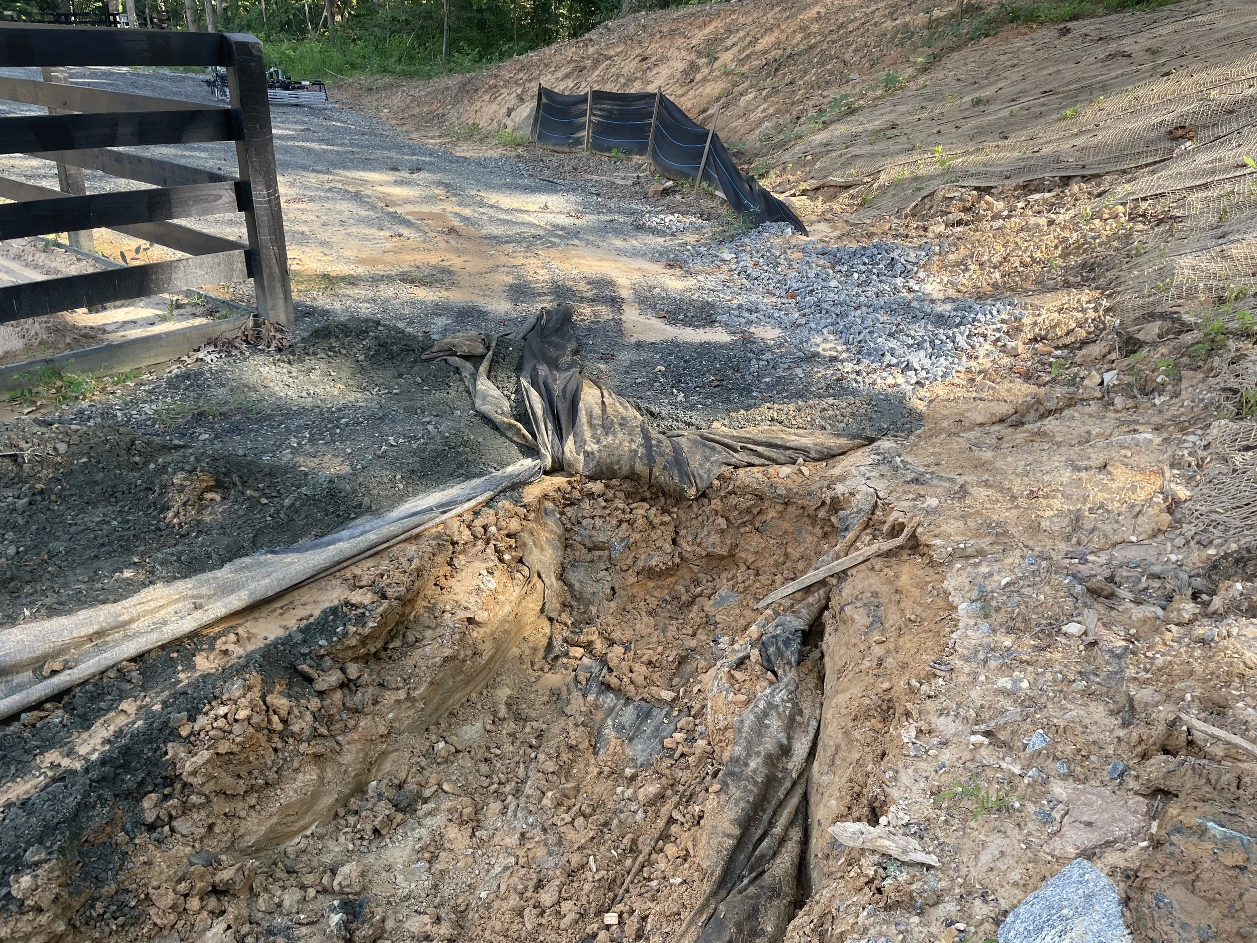 Sediment-clogged perimeter drain above a horse farm arena and parking area in Kennesaw, Georgia.