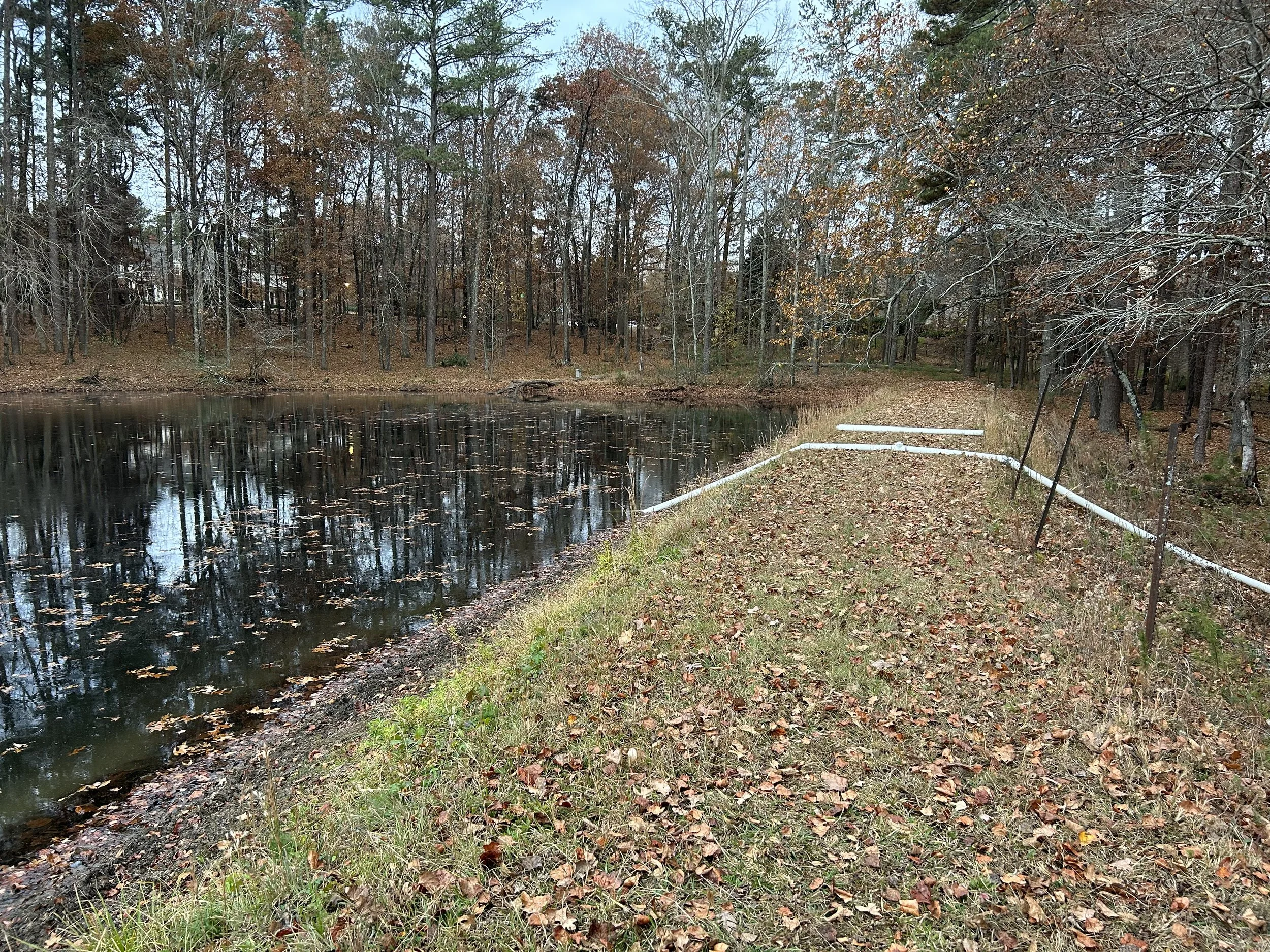 Pond siphon installed to begin lowering the water level for dredging at a Kennesaw, Georgia pond.