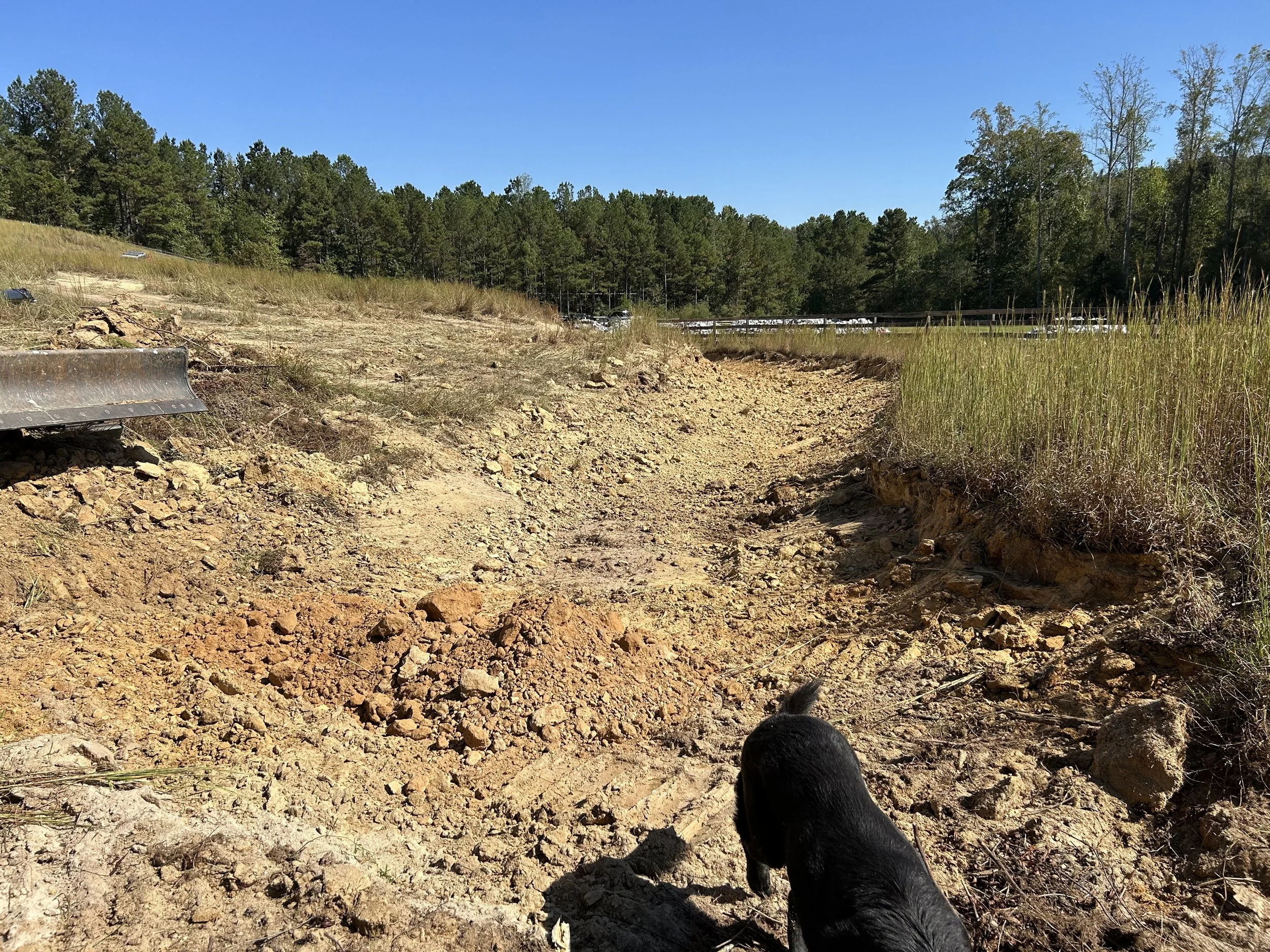 Excavation cut toward the top of the reconstructed pond dam before installation of geotextile and riprap in Fairburn, Georgia