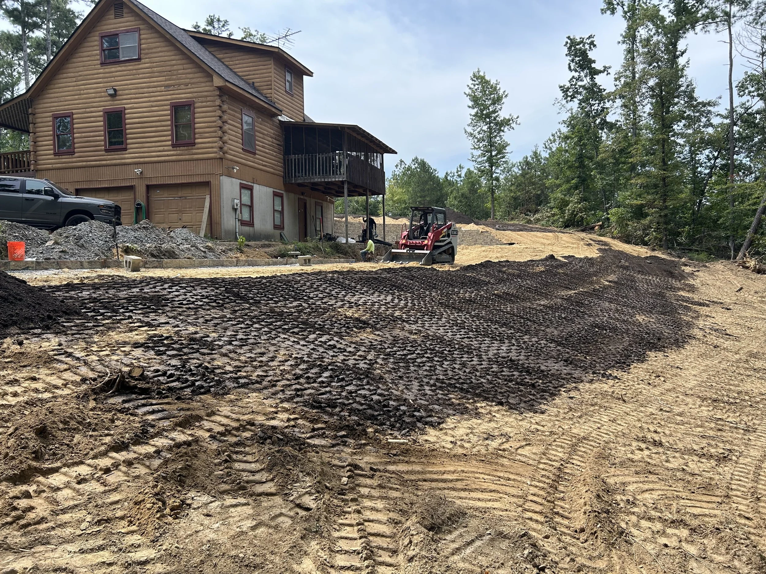 Major cut-and-fill grading for a Dallas, Georgia property, with more than 500 cubic yards of on-site soil excavated and redistributed to expand usable yard area and prepare the site for new retaining walls. Cuts exceeding three feet were carefully bl
