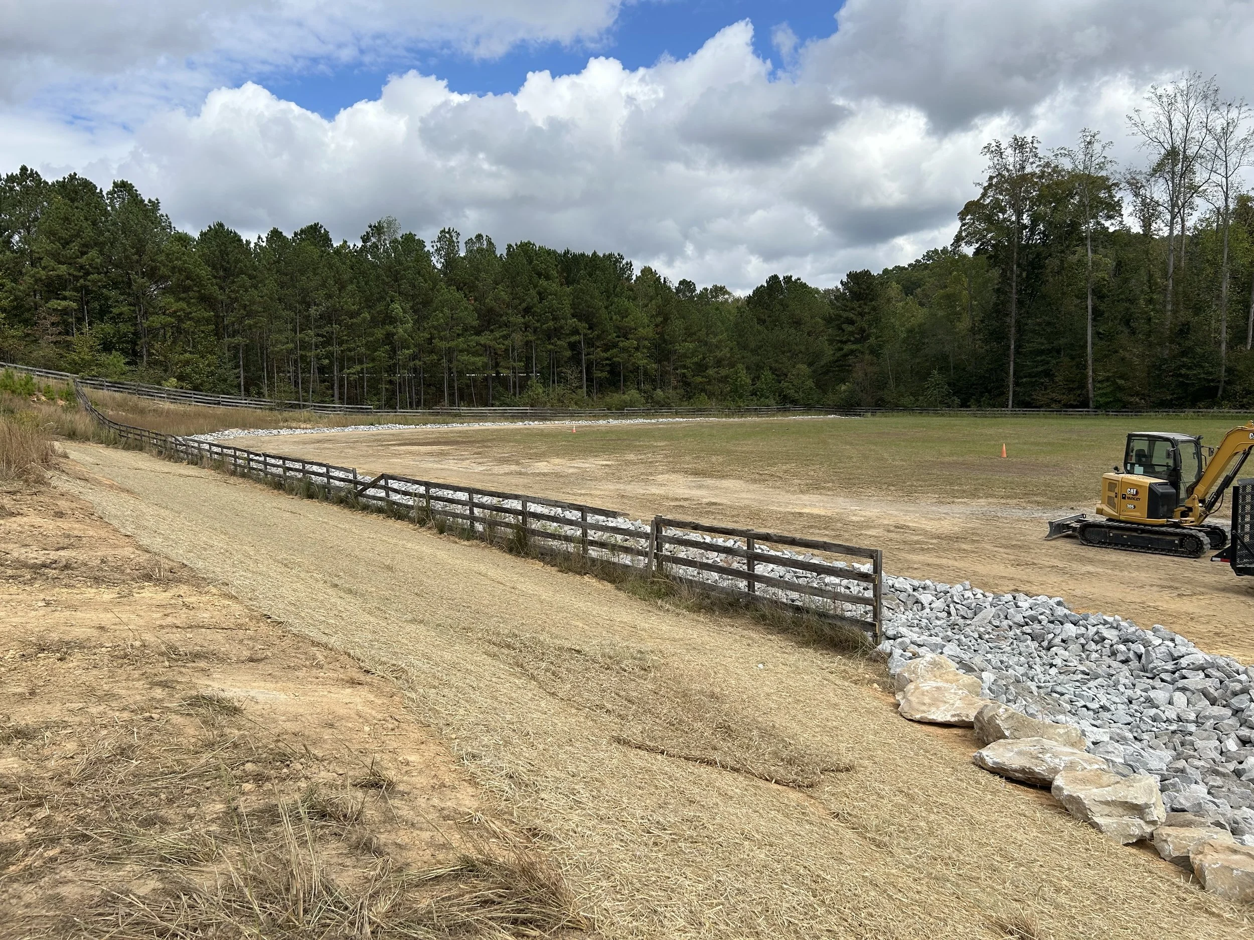 Engineered rock-lined drainage channel in Fairburn, GA. Approximately 700 feet of channel was profiled to engineered grades and lined with geotextile and approximately 540 tons of riprap to establish controlled drainage through the property and a sta