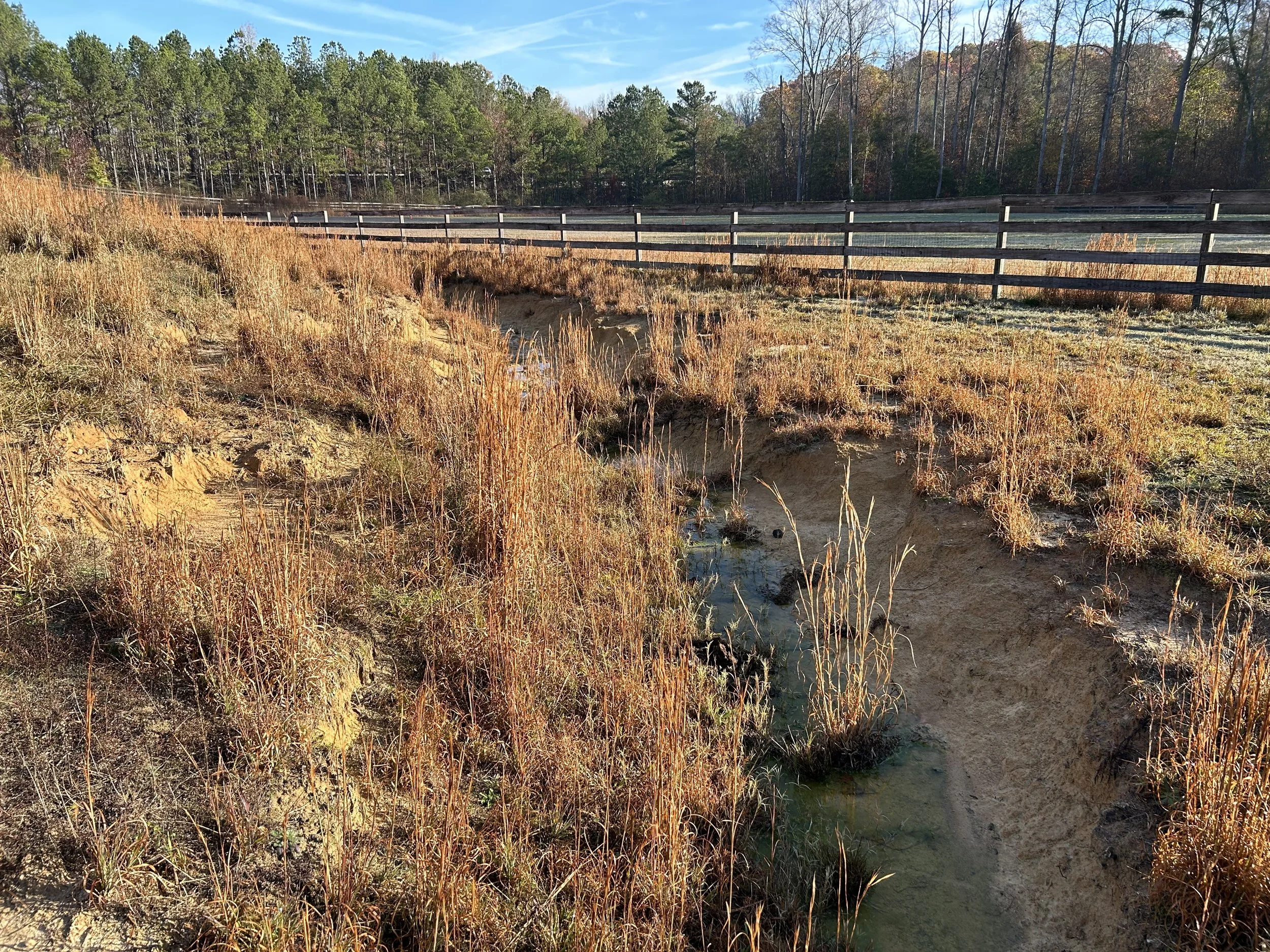 Engineered rock-lined drainage channel in Fairburn, GA. Approximately 700 feet of channel was profiled to engineered grades and lined with geotextile and approximately 540 tons of riprap to establish controlled drainage through the property and a sta