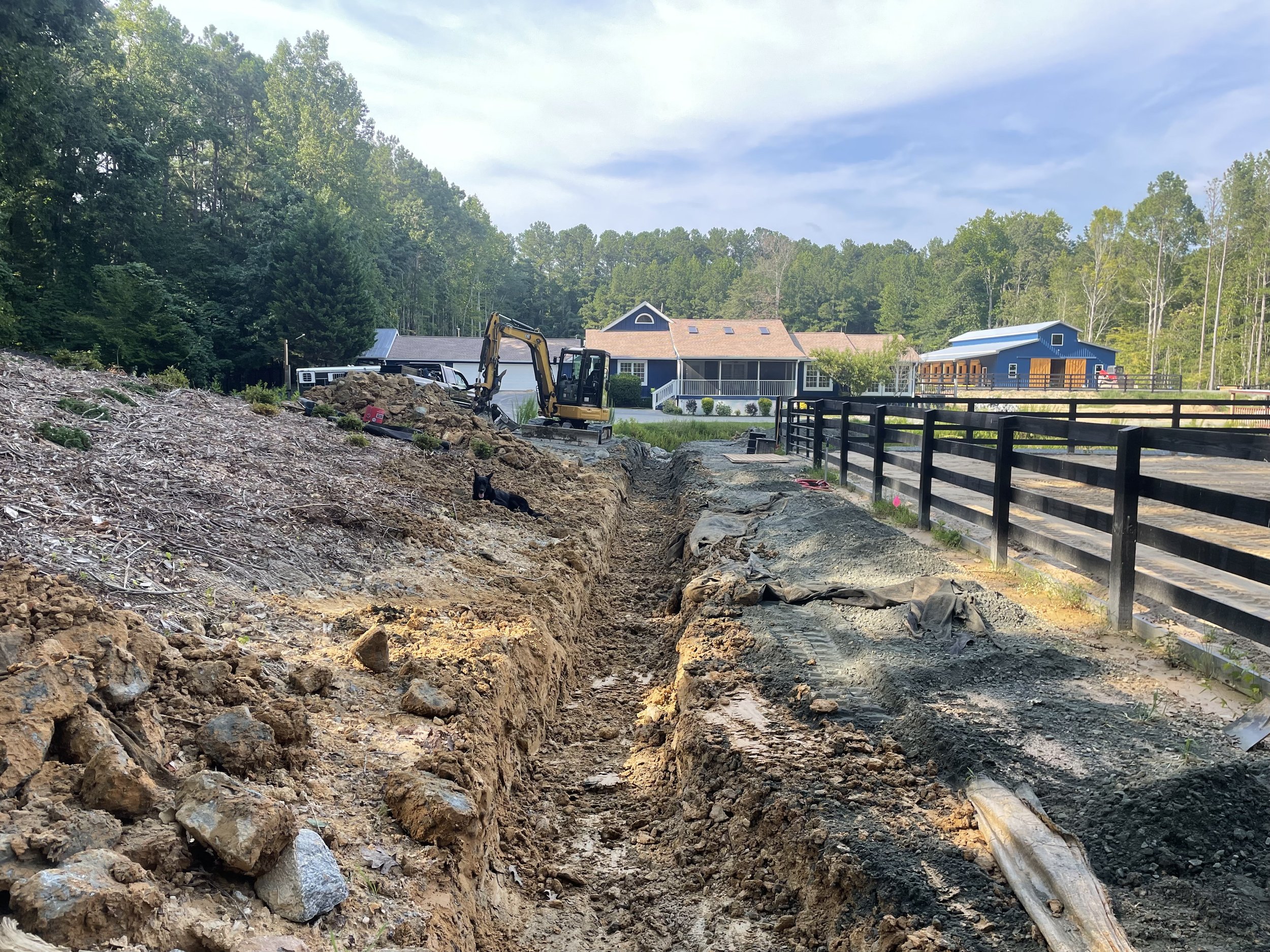 Perimeter drainage channel reopened to restore runoff interception above the horse farm parking and arena area.
