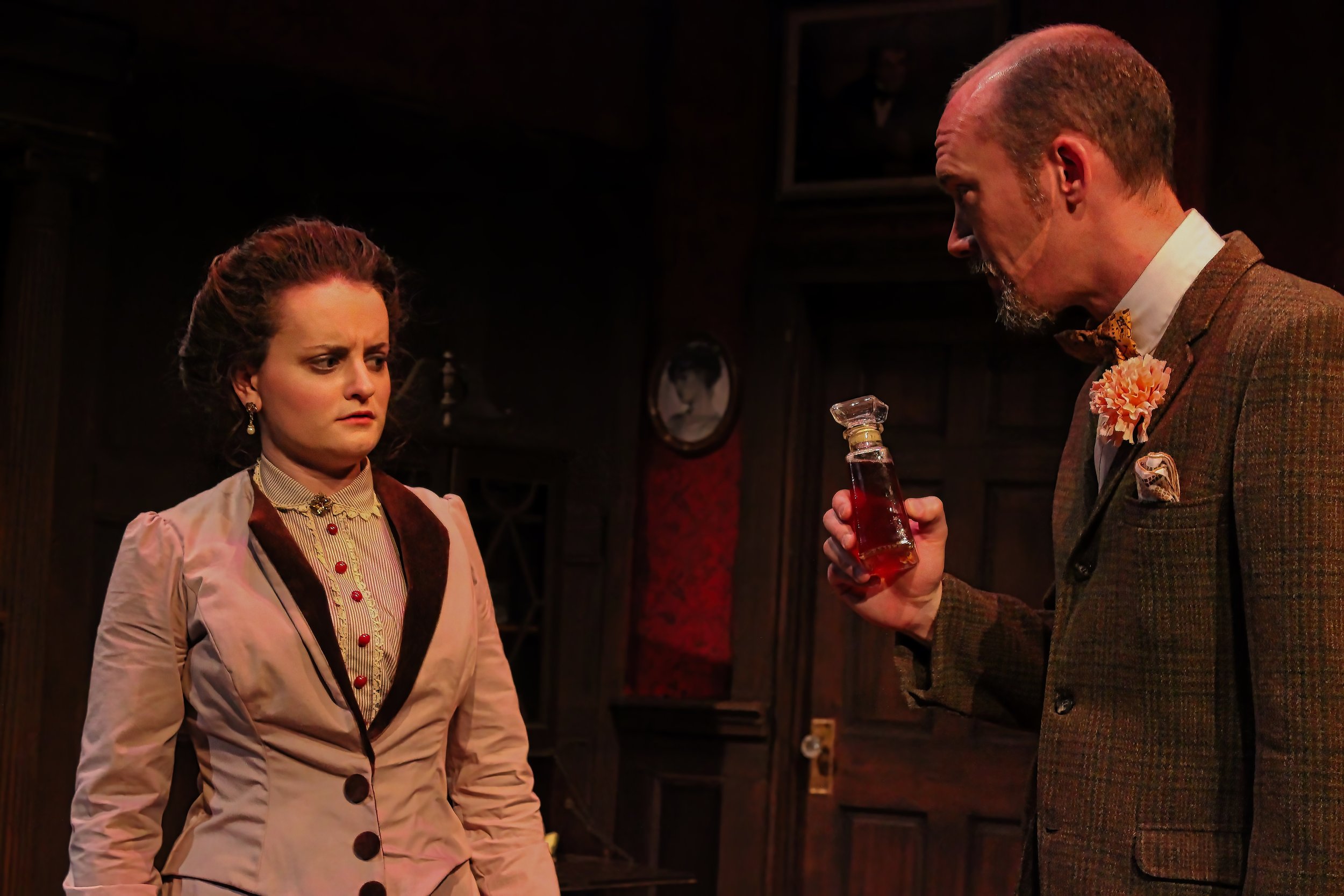 A woman looking angry at a man holding a bottle of liquor in a dimly lit room with vintage decor.
