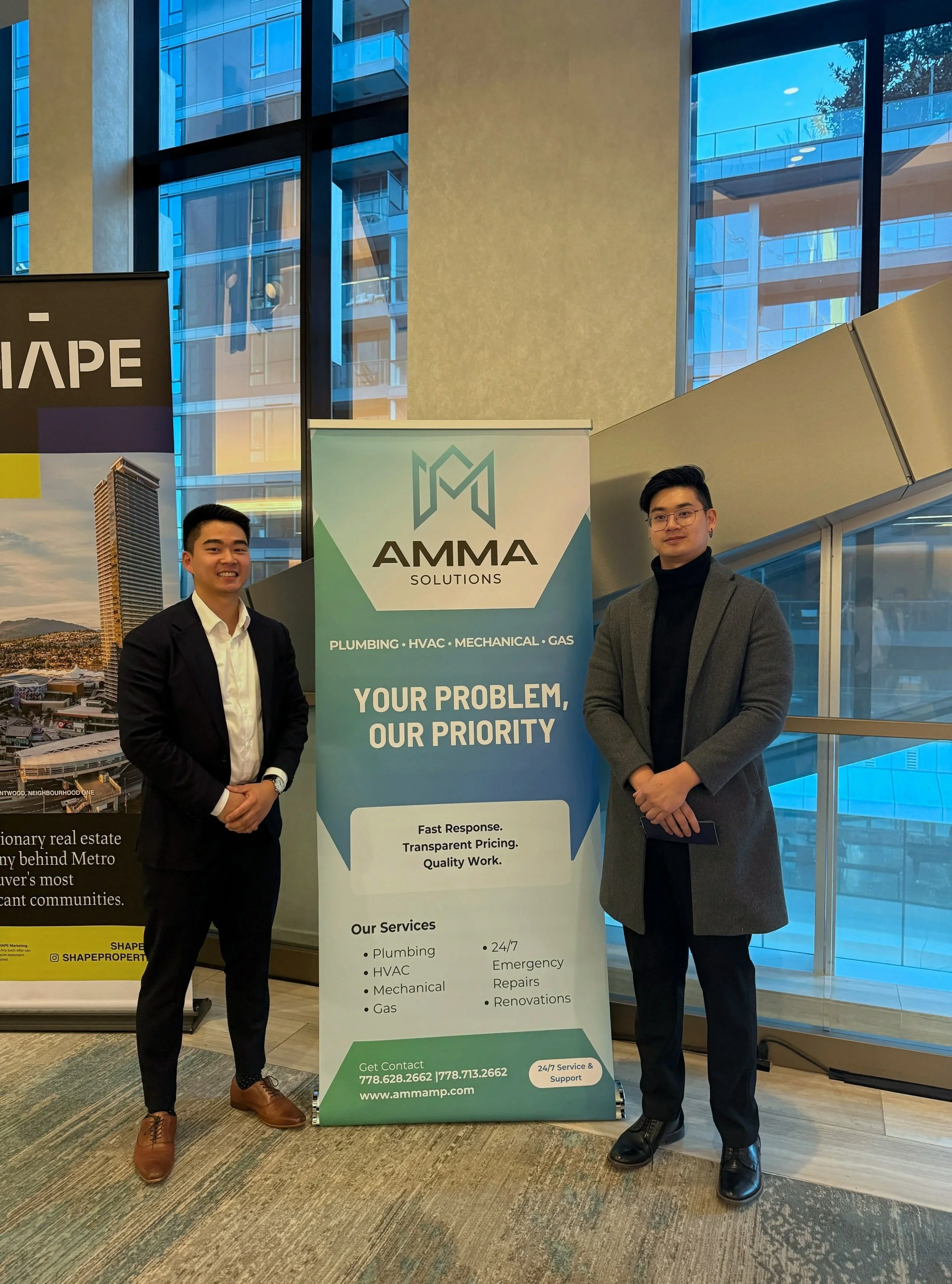 AMMA Solutions team standing beside company banner while sponsoring a RE/MAX real estate gala event in Vancouver BC