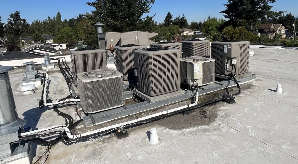 Rooftop HVAC heat pump and air conditioning units undergoing preventative maintenance service for a commercial building in Vancouver by AMMA Solutions
