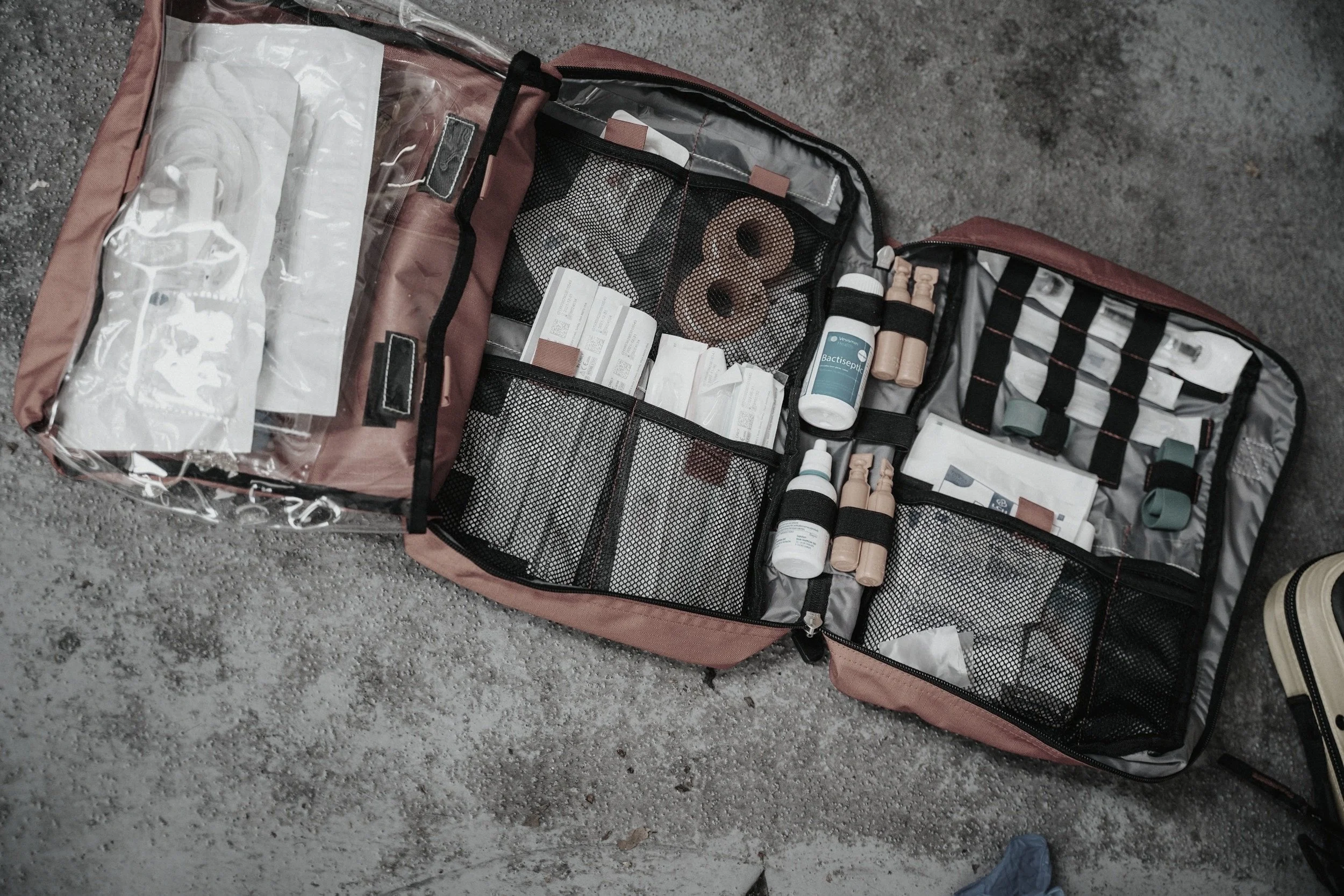 Open medical kit with various supplies, medications, and bottles organized inside.