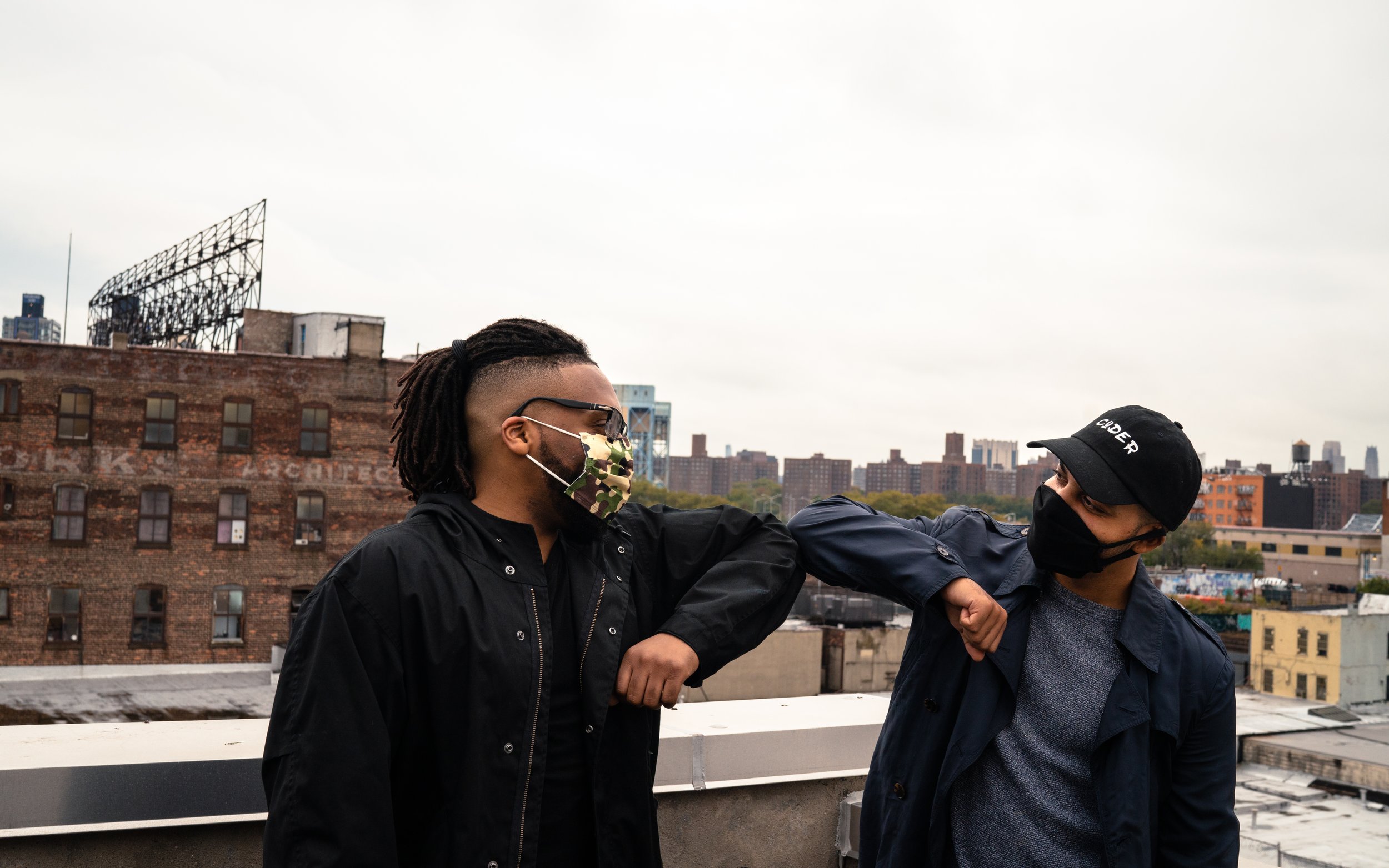 TKH_RR_Michael McCray and Cesar elbow bump each other on the rooftop of The Knowledge House.jpg