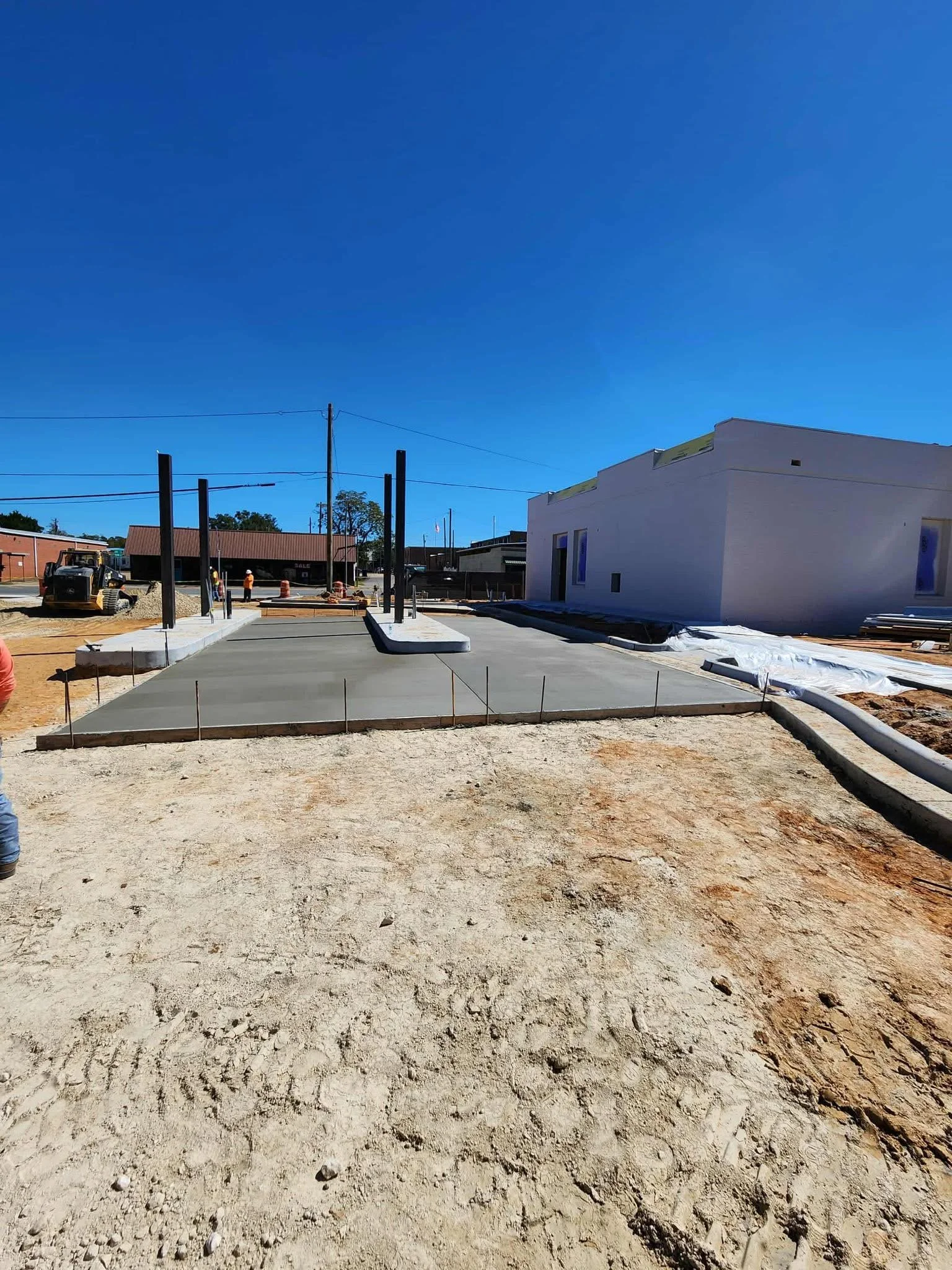 Construction site with freshly poured concrete sidewalk.