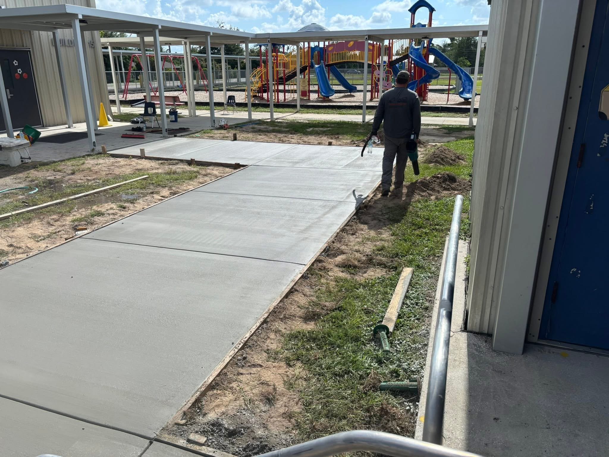 Freshly poured concrete sidewalk connecting school buildings.