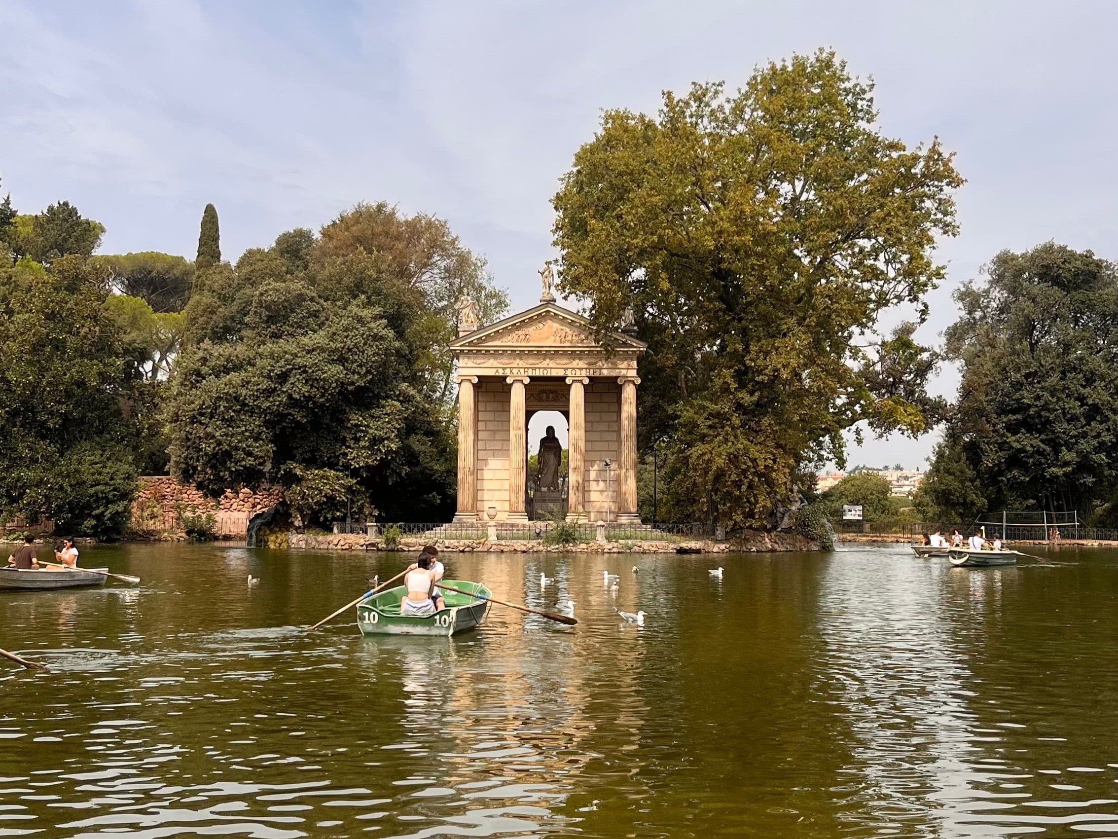 Rowing a boat on the lake at Villa Borghese, experiencing peaceful nature in Rome.