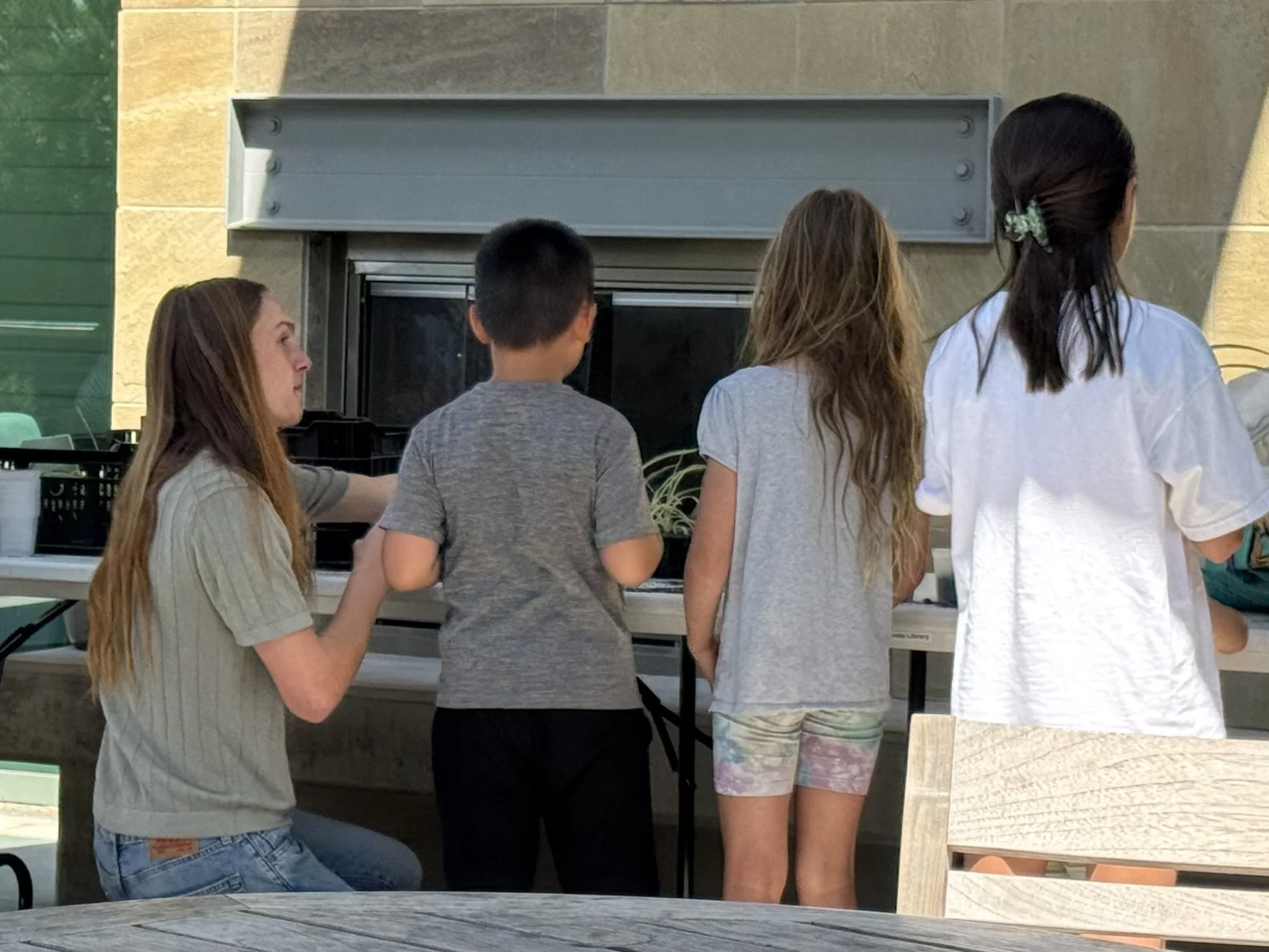 Planting Smiles' founder teaching three children about the environment.