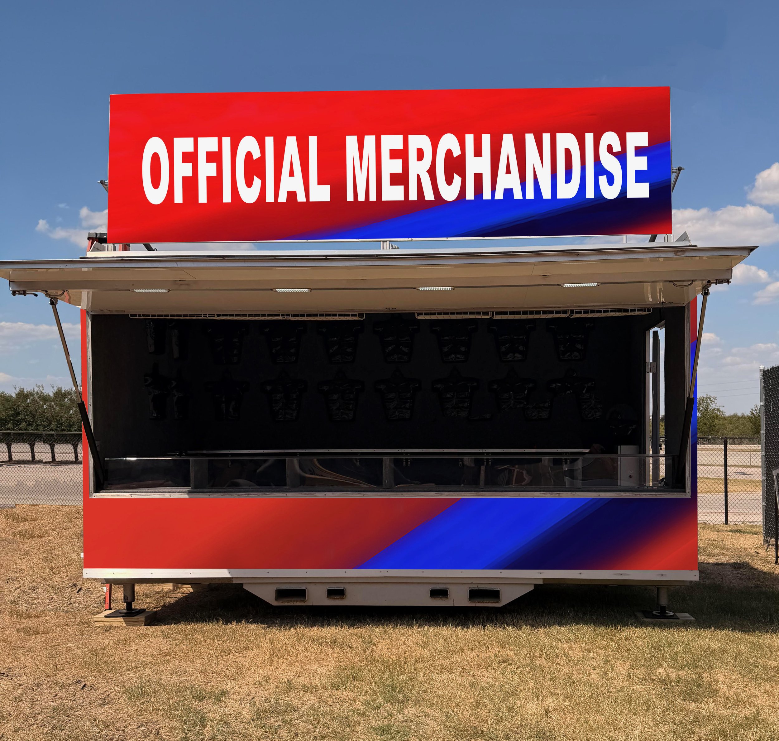 Empty merchandise stand with a red, white, and blue sign that reads 'Official Merchandise'