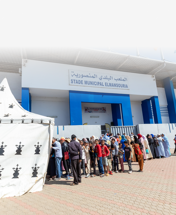 People standing in line outside Stade Municipal El Mansouria stadium.