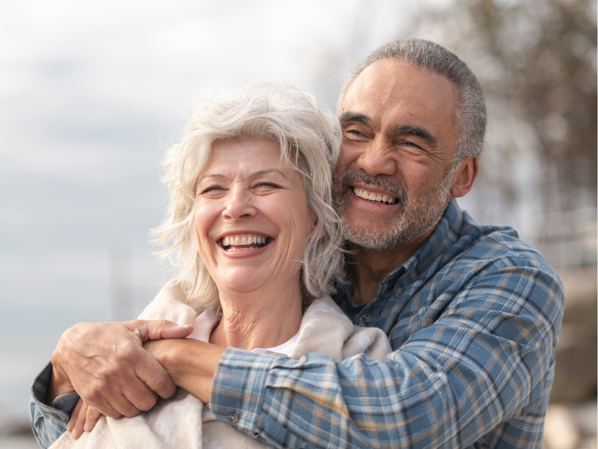 Happy senior couple smiling together outdoors representing lifelong oral health and general dentistry care at Dental Excellence