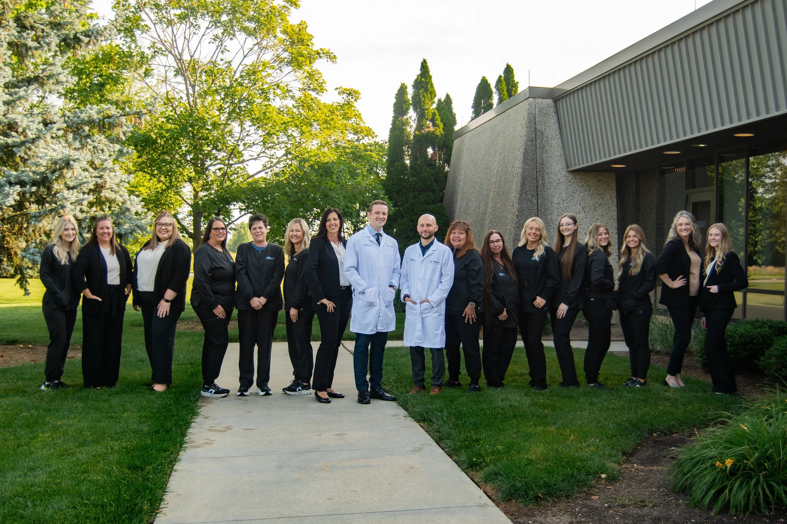 Dental Excellence of Bowling Green team standing outside the office building, including dentists and staff providing compassionate family and cosmetic dental care in Northwest Ohio.