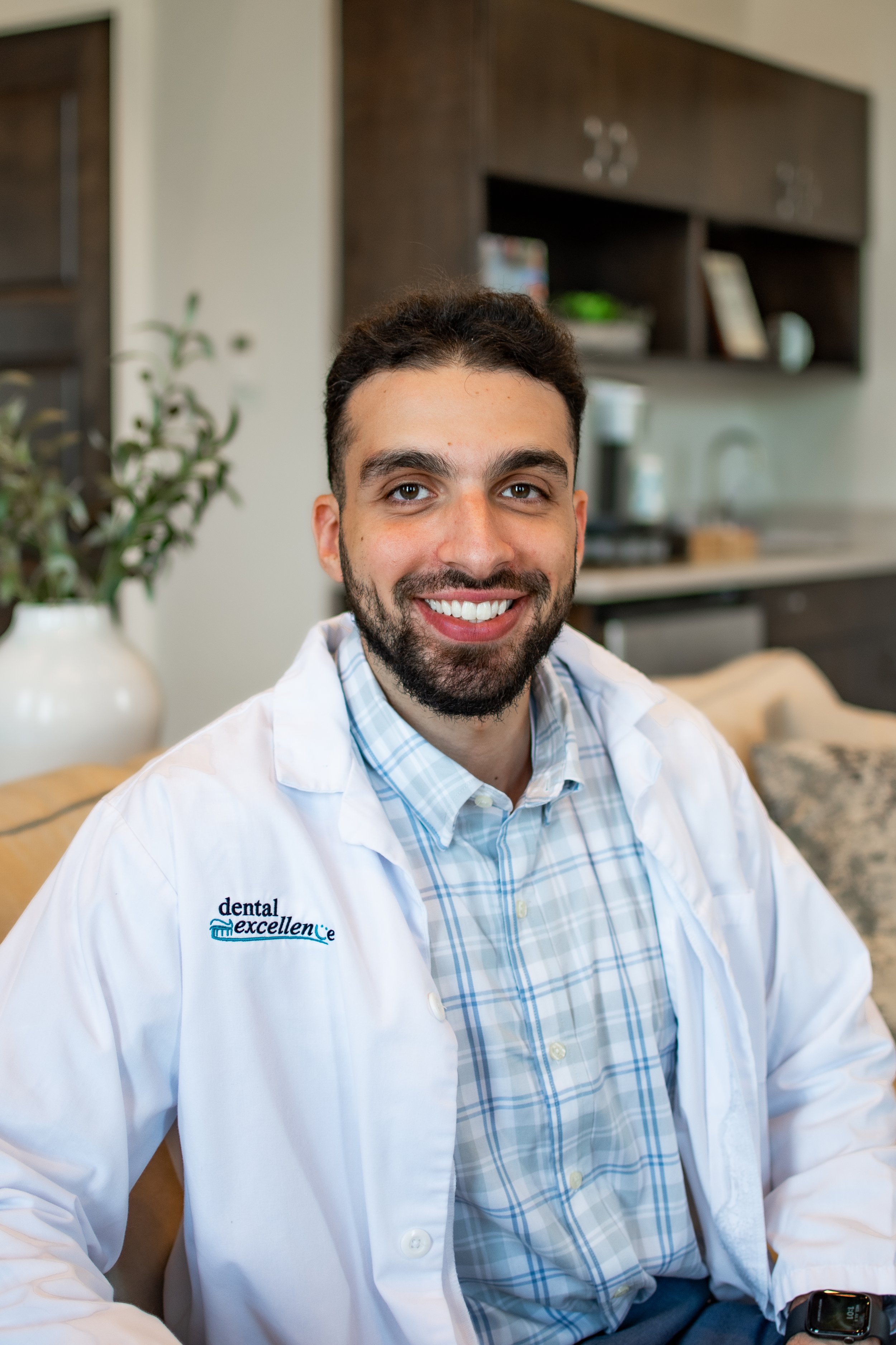 Dr. Adam Jazaerly smiles while wearing a Dental Excellence lab coat in the office, providing comprehensive family and general dentistry in Northwest Ohio.